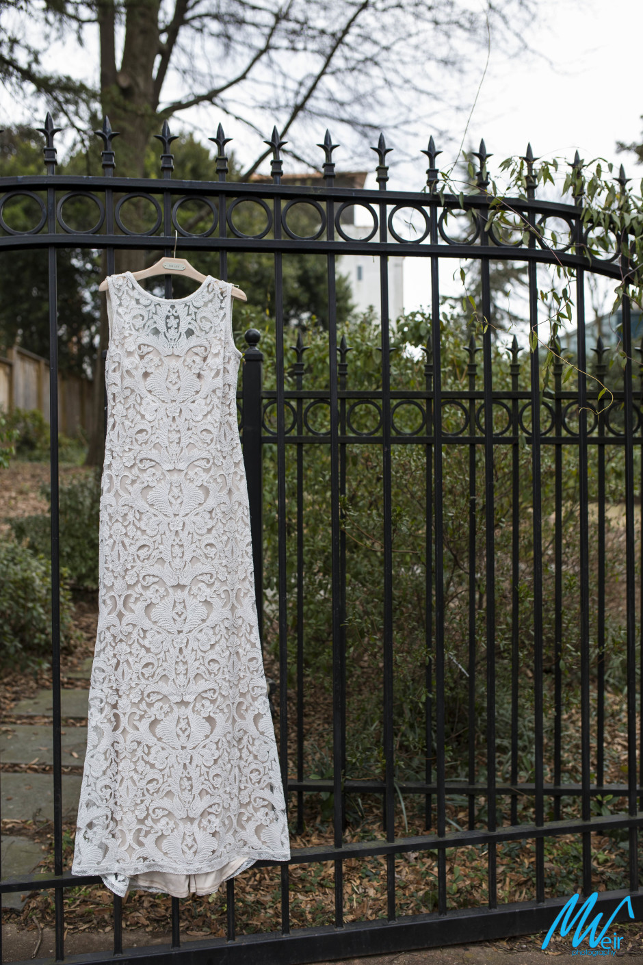 bridal gown hanging on a fence