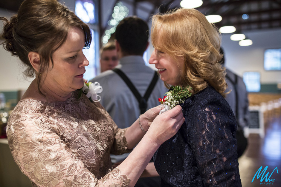 mother of the bride and mother of the groom pinning corsages
