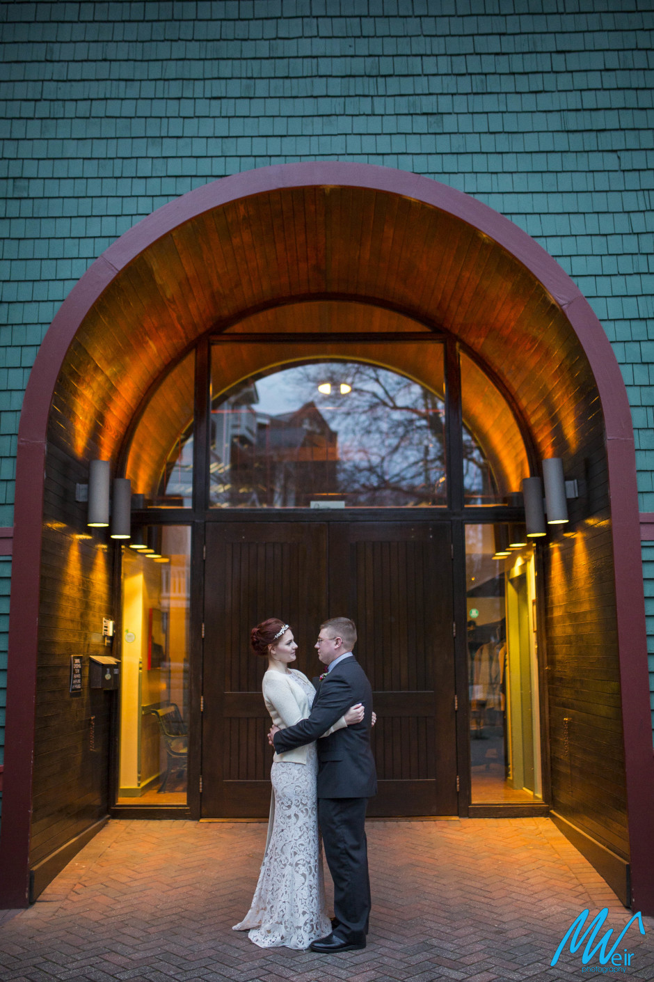 bride and groom hugging in front of trolley barn entrance