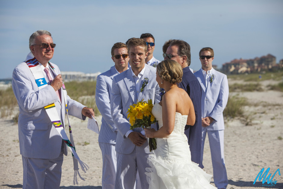 father giving away his daughter during a beach themed wedding ceremony
