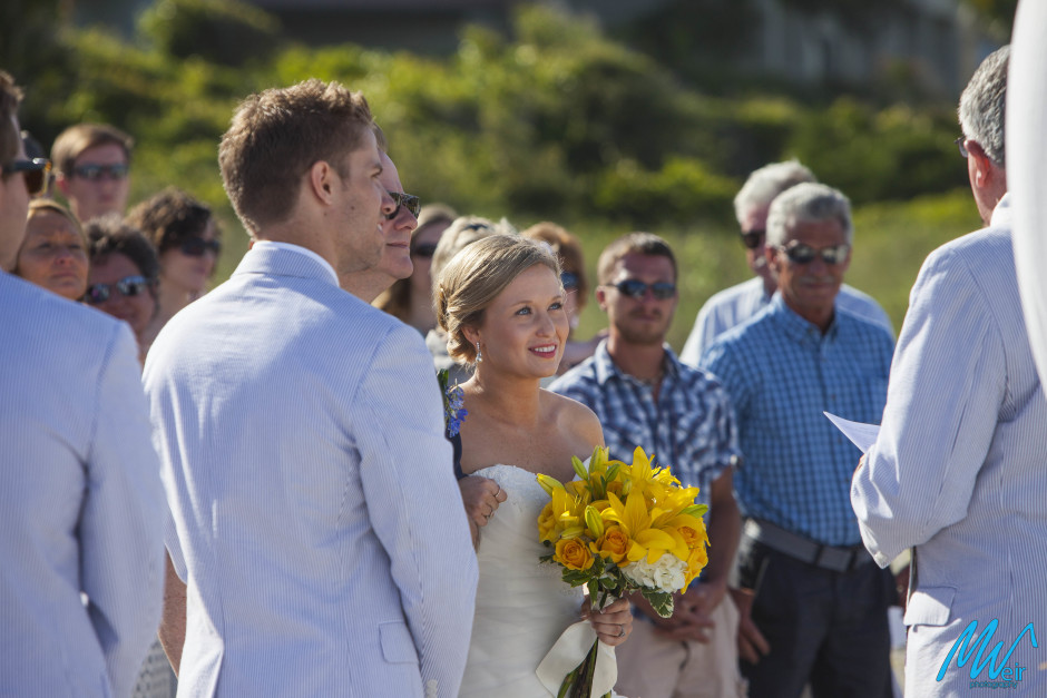 father giving away his daughter during a beach wedding ceremony