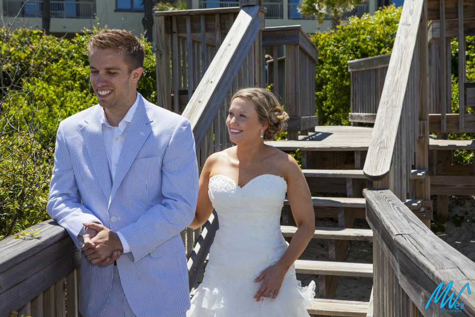 bride tapping groom on shoulder during first look on the board walk