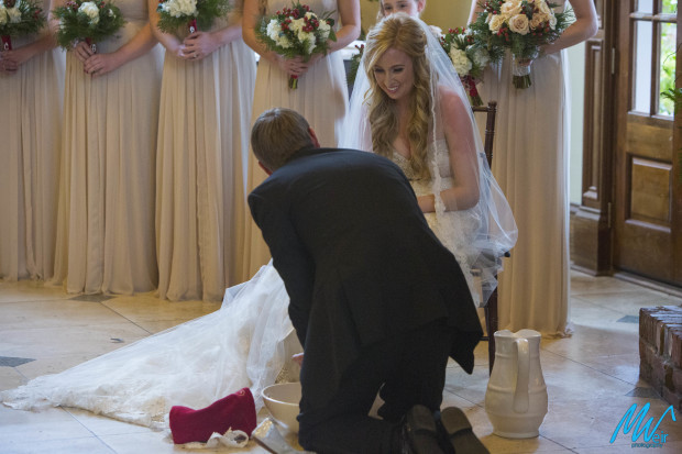 groom washes brides feet during wedding ceremony