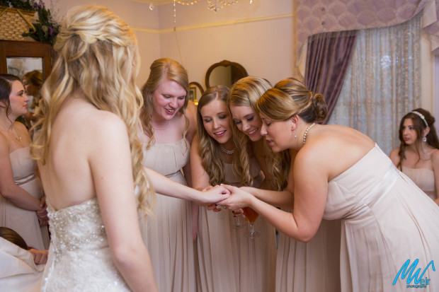 bridesmaids look at the brides engagement ring