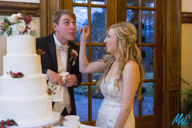 bride feeds grooms wedding cake
