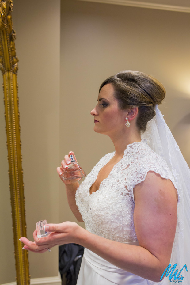 bride sprays perfume before ceremony