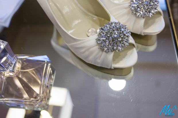 brides shoes and perfume bottle on glass table