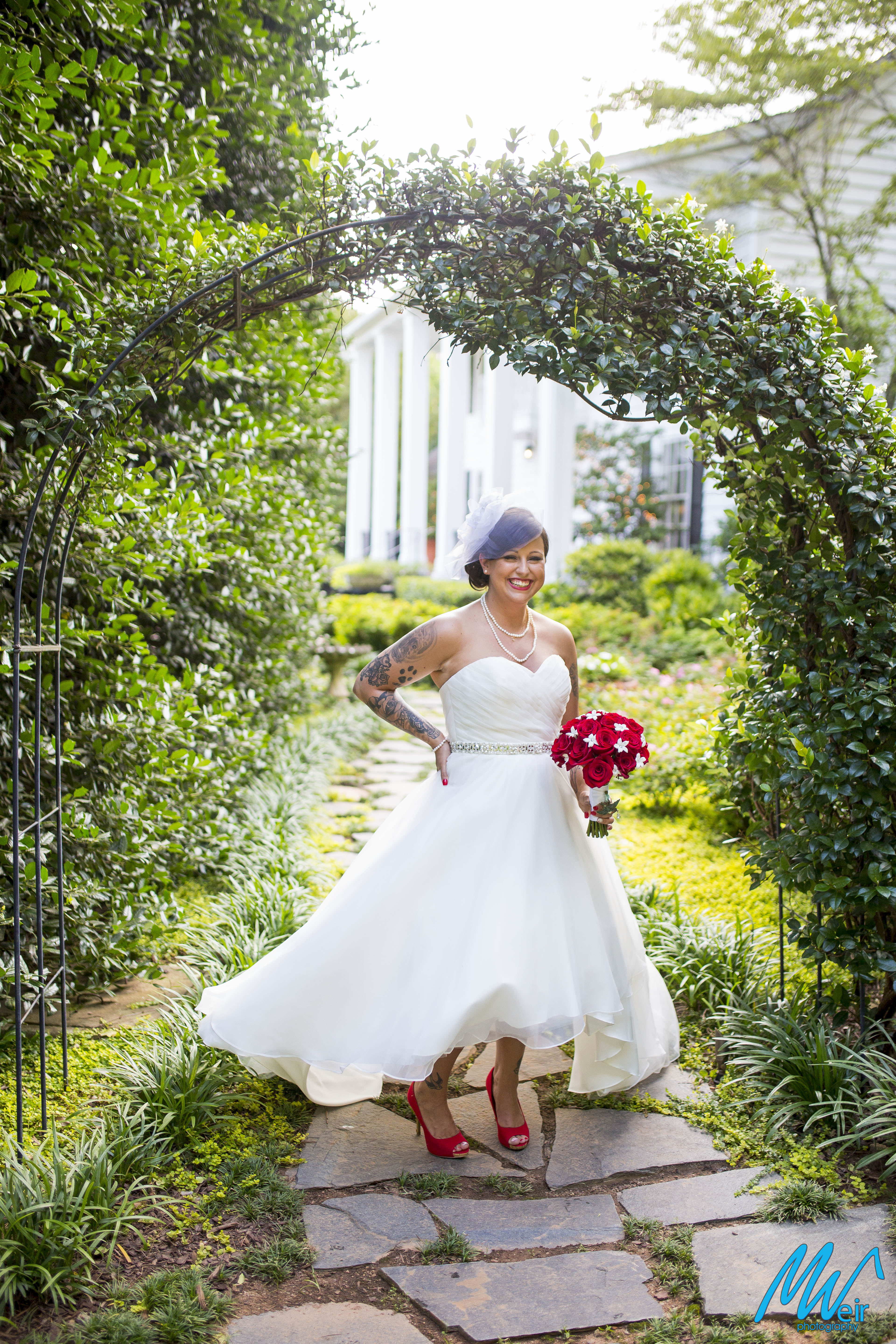 bride under floral arch