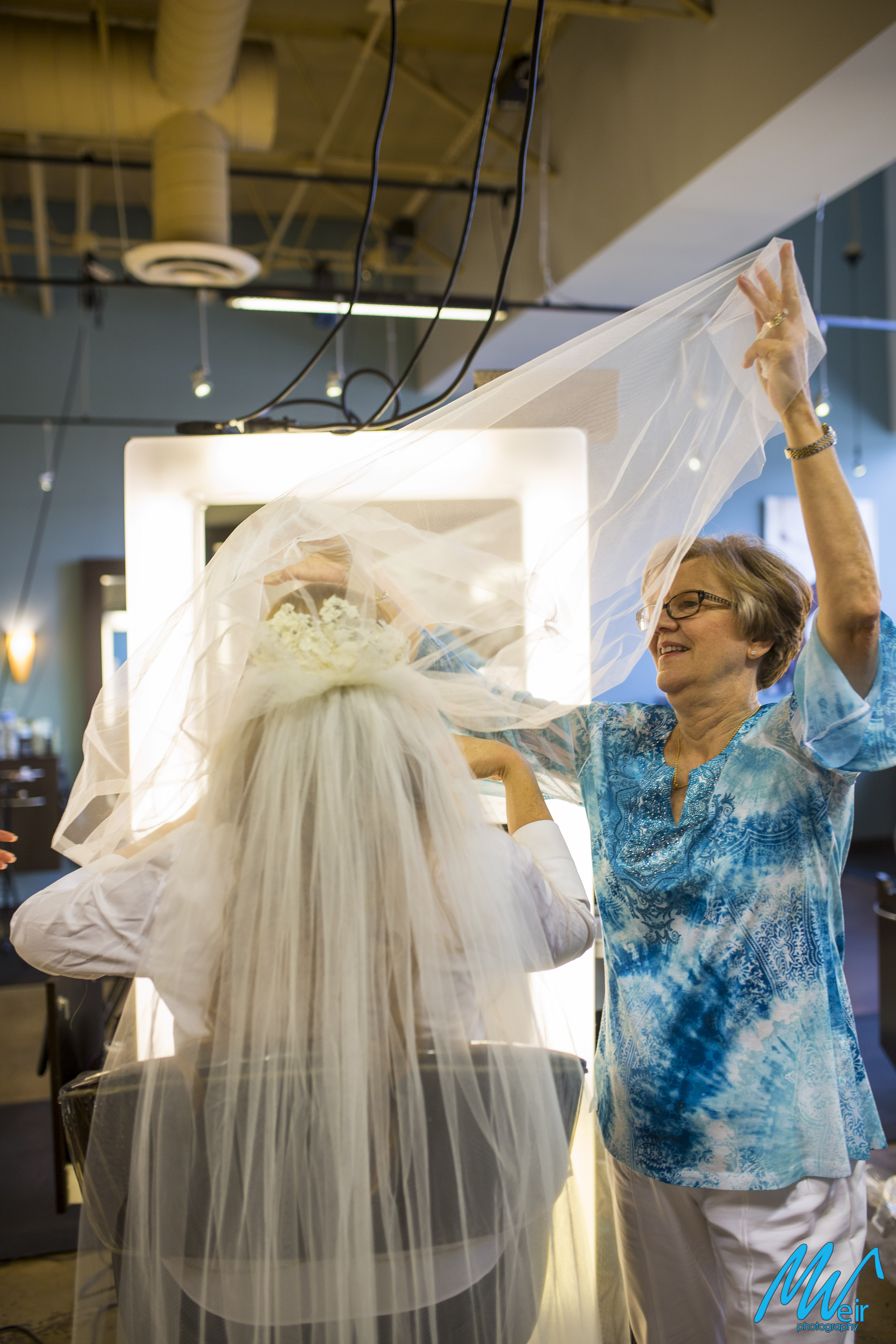 mother of the bride pulling the veil over her head