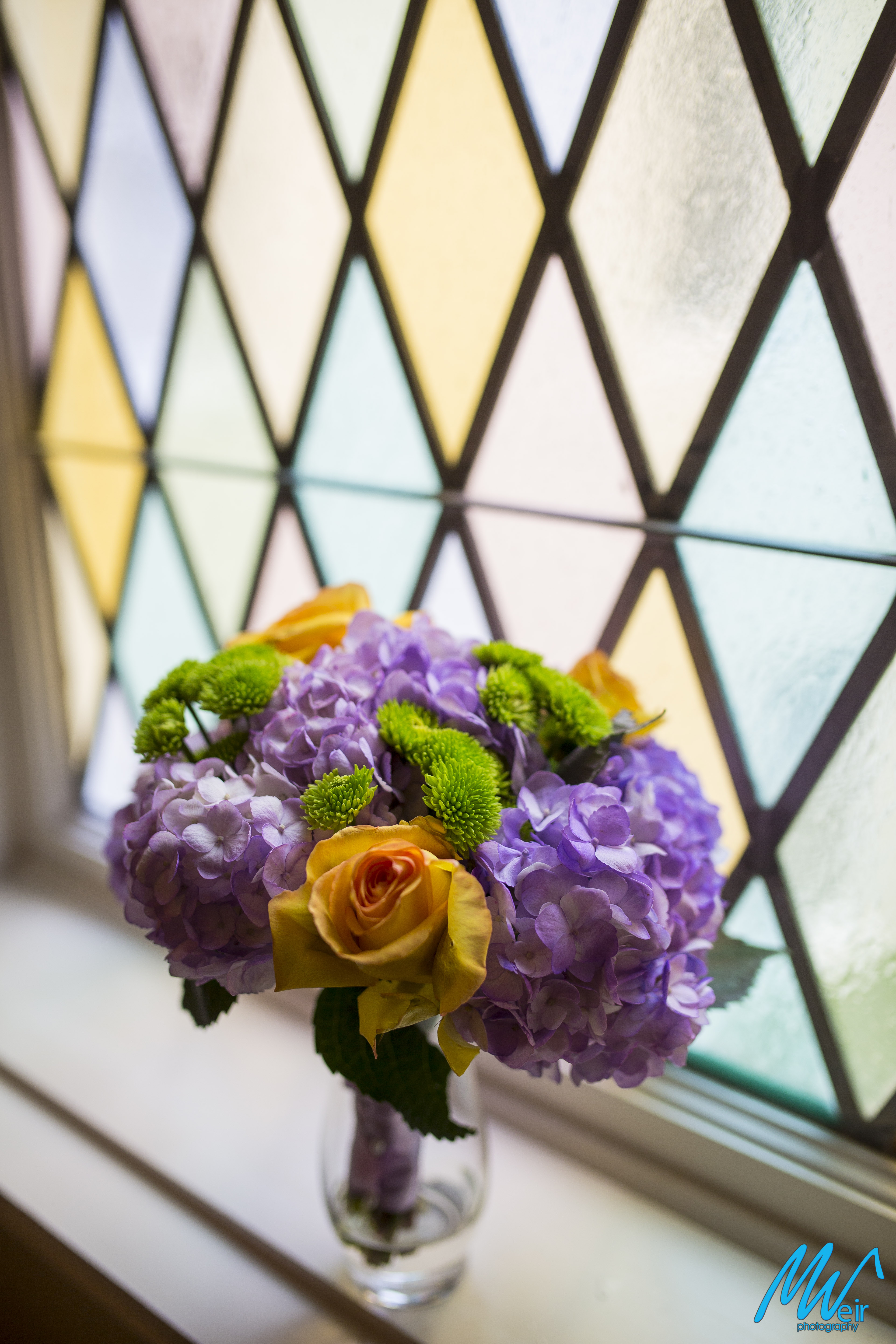 bridesmaid bouquet in front of stain glass window