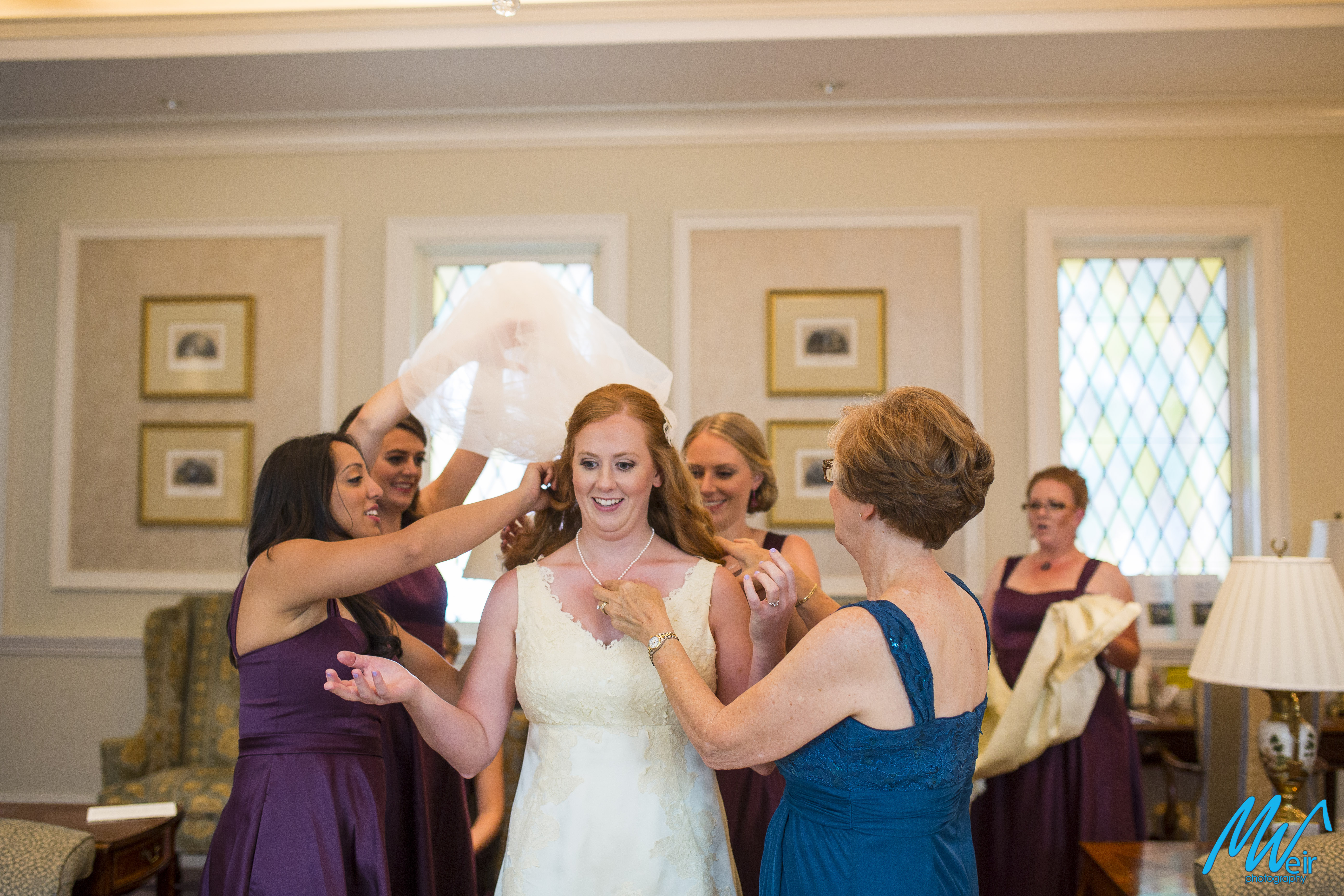 everyone helps bride put her jewelry on