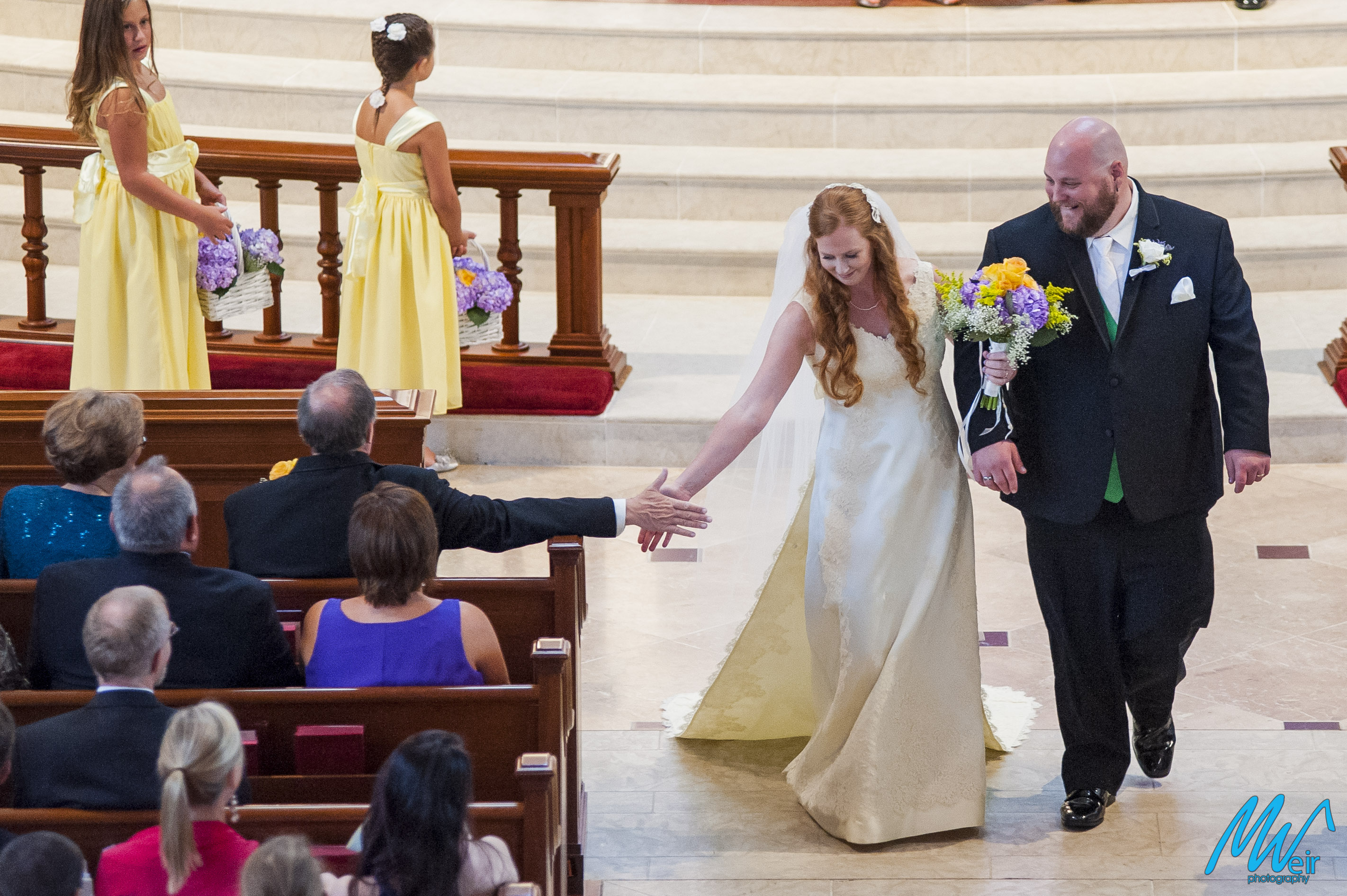 bride high fives dad on the way back up aisle after getting married
