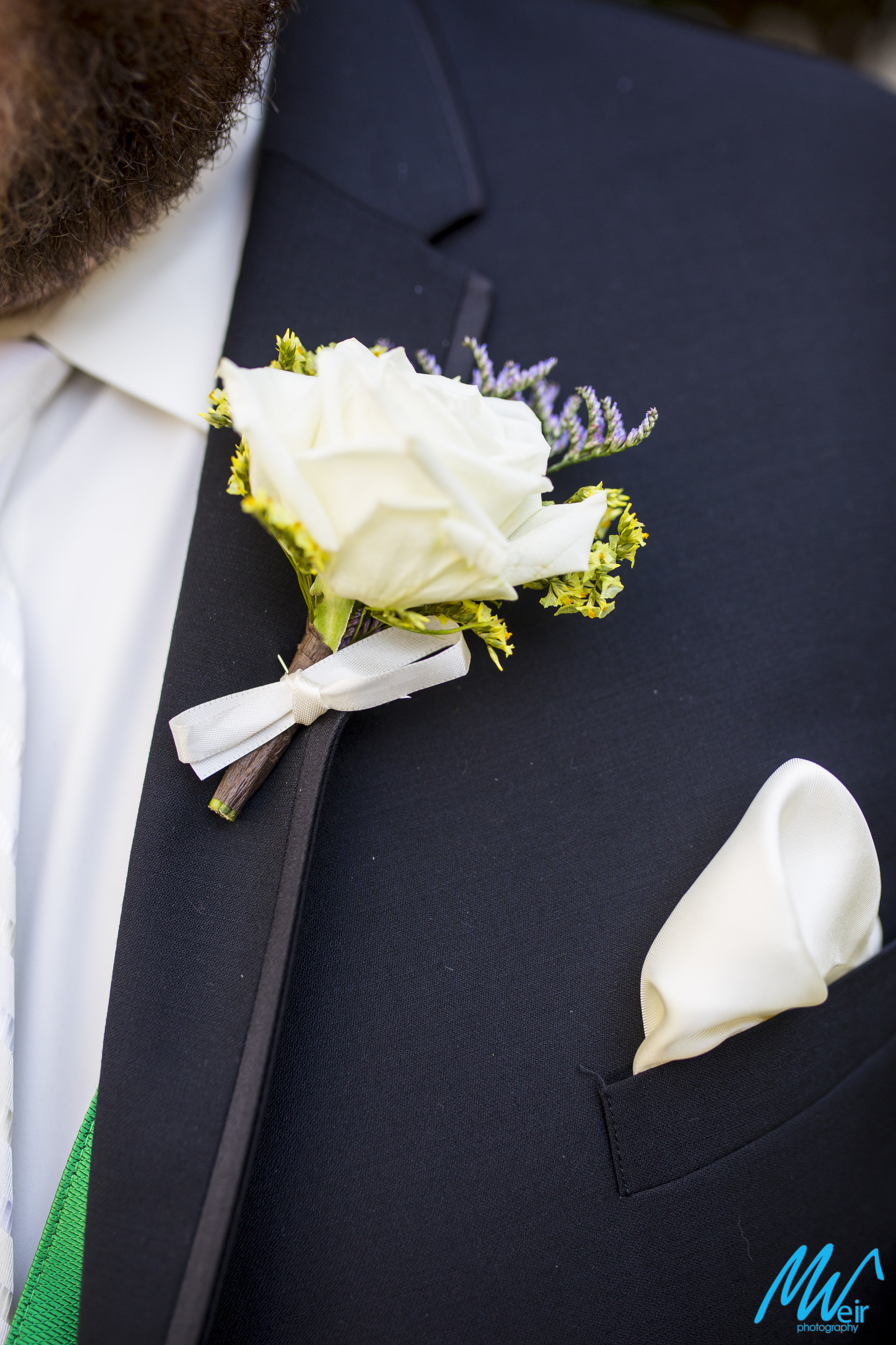 detail of the grooms lapel and boutonniere