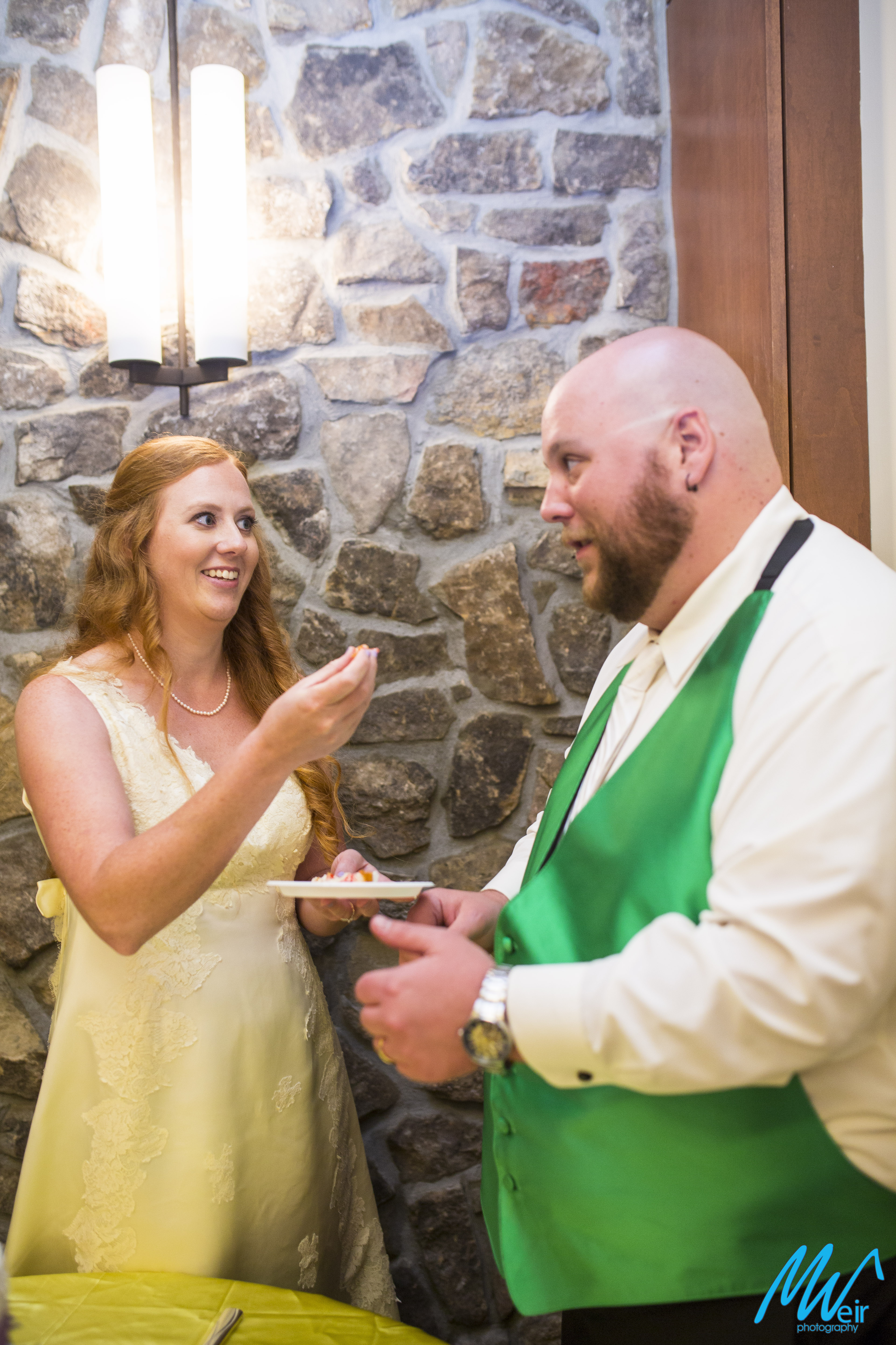 bride feeds groom wedding cake after cutting it