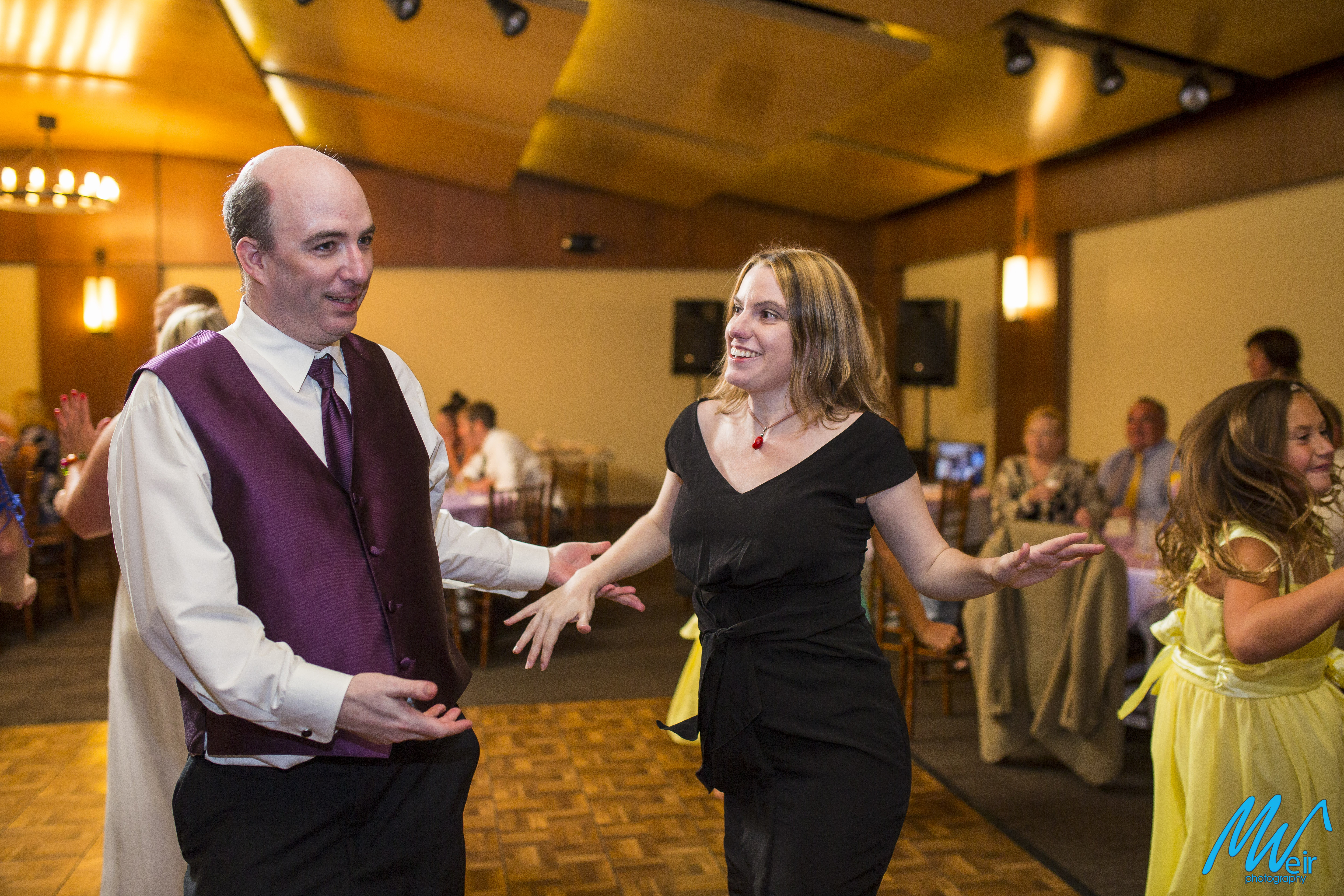 groomsmen dancing with wife during wedding reception