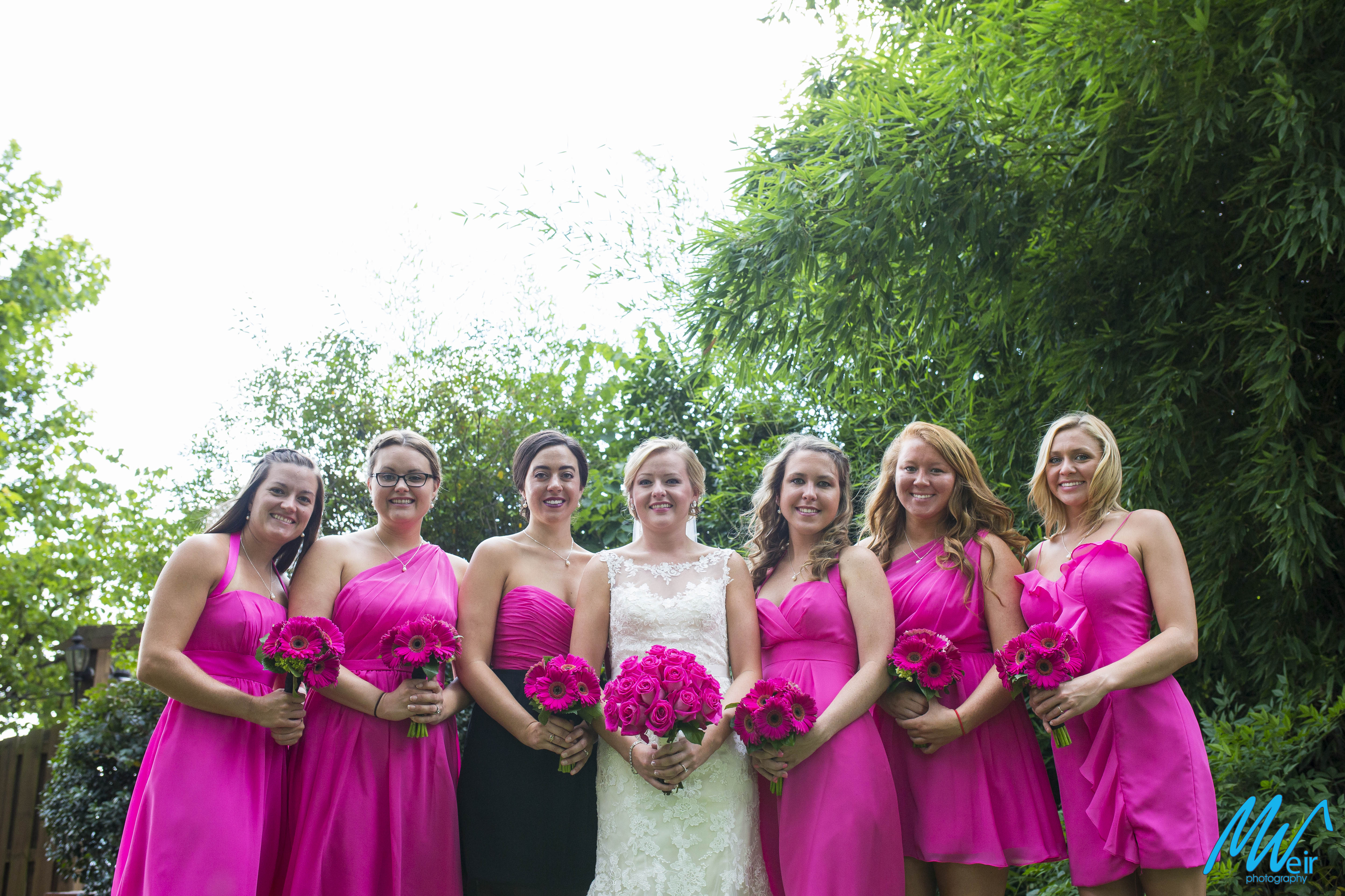 bridemaids in pink dresses in a garden