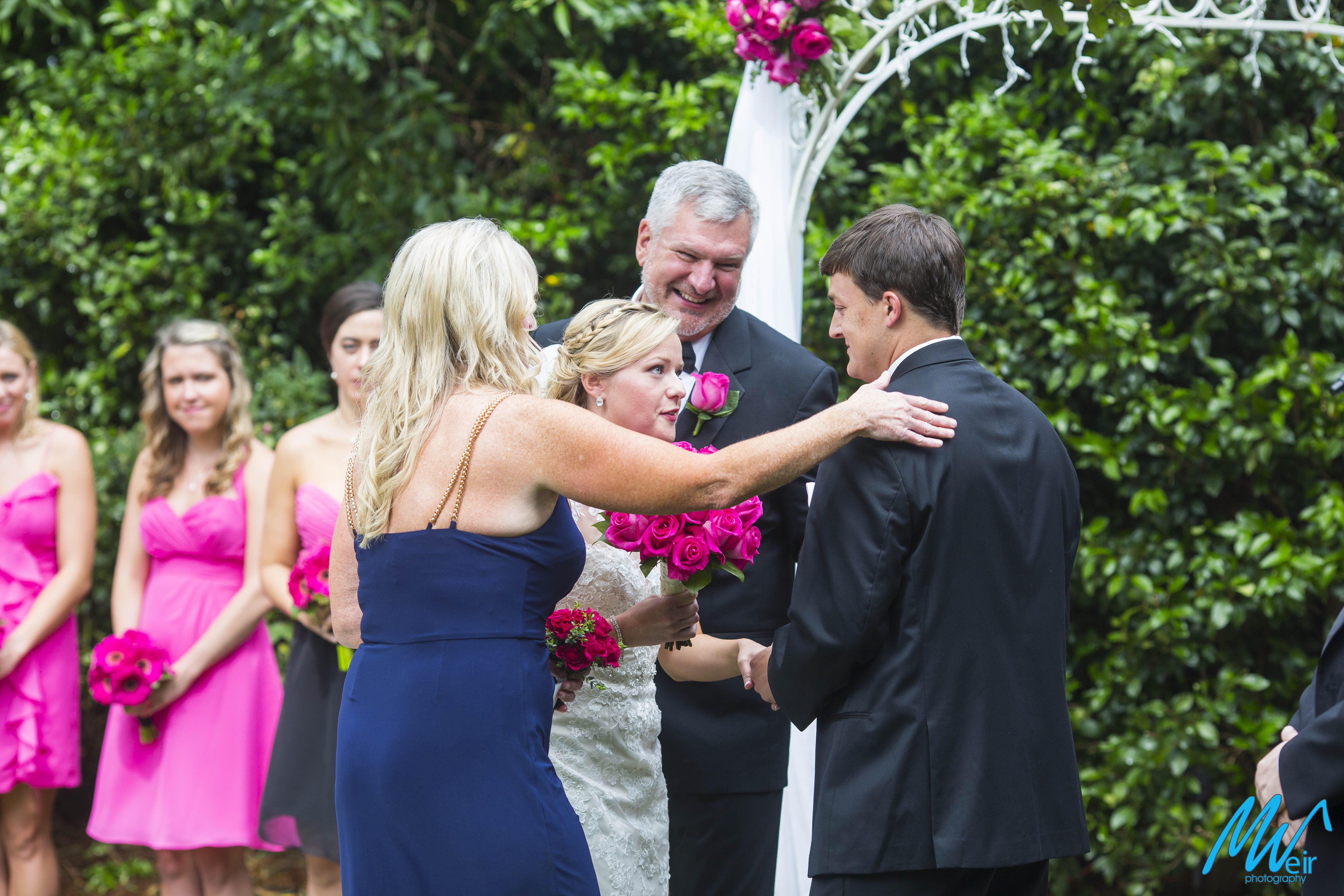 brides parents embracing groom