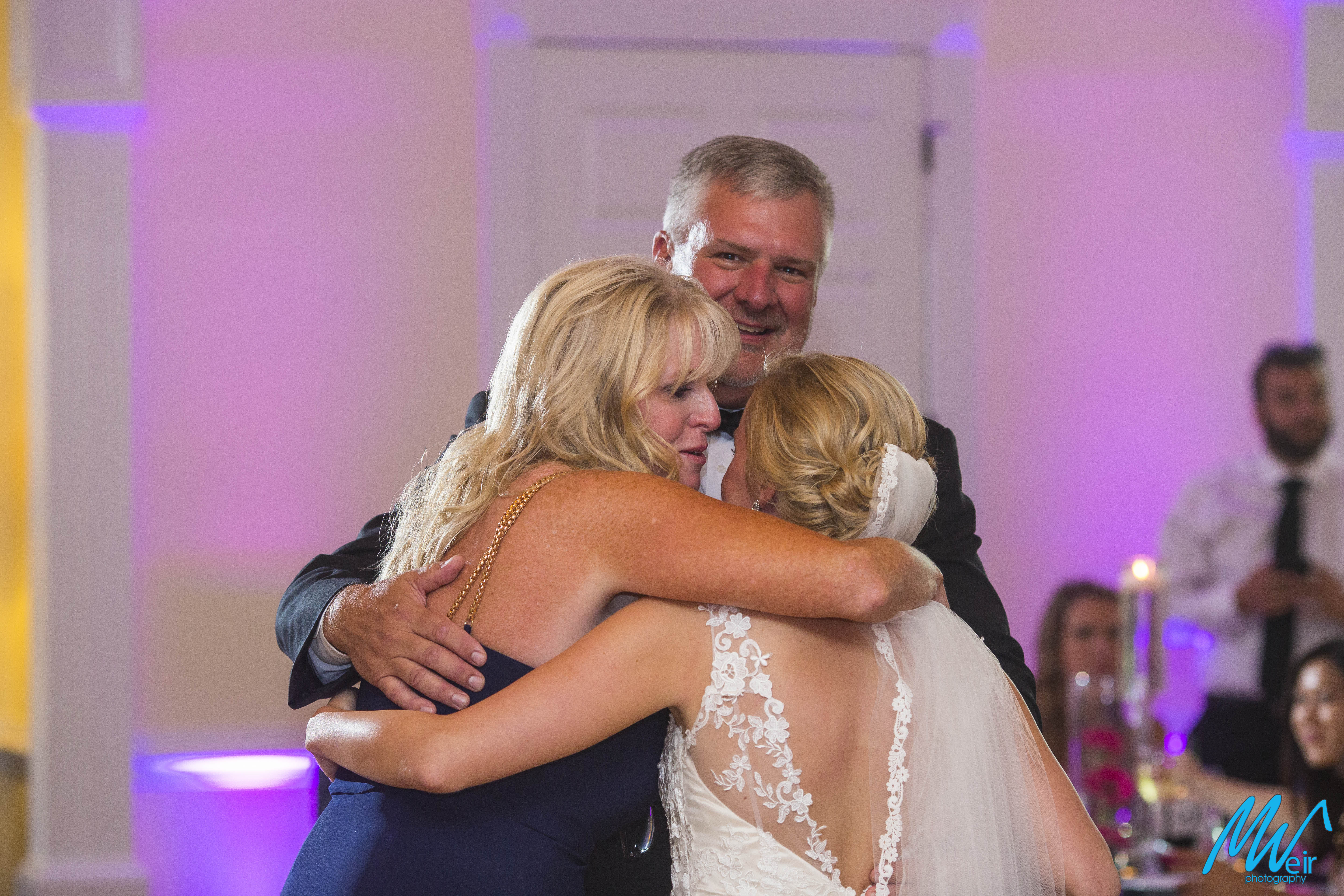 brides parents embrace bride