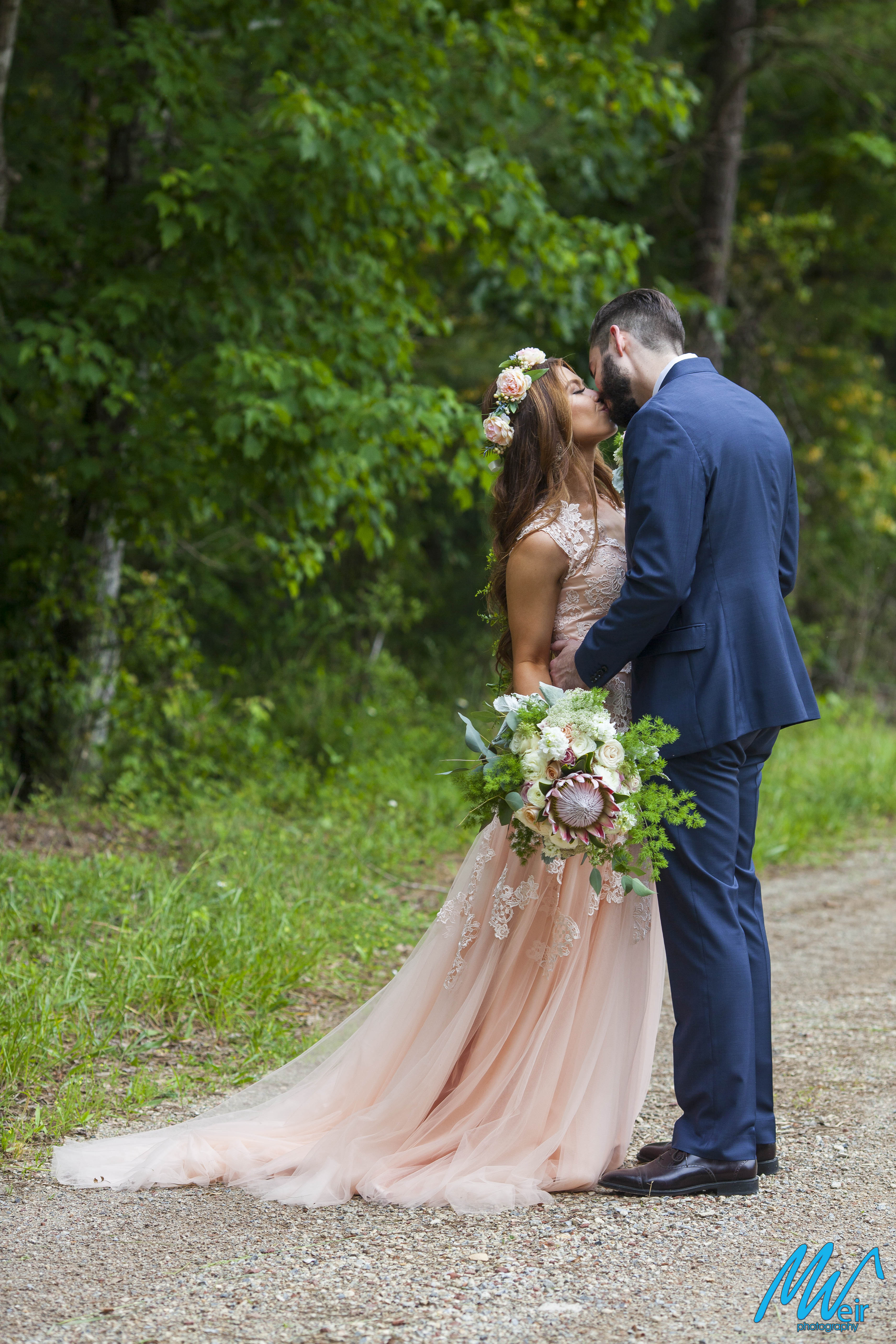 bride and groom kiss on a dirt road