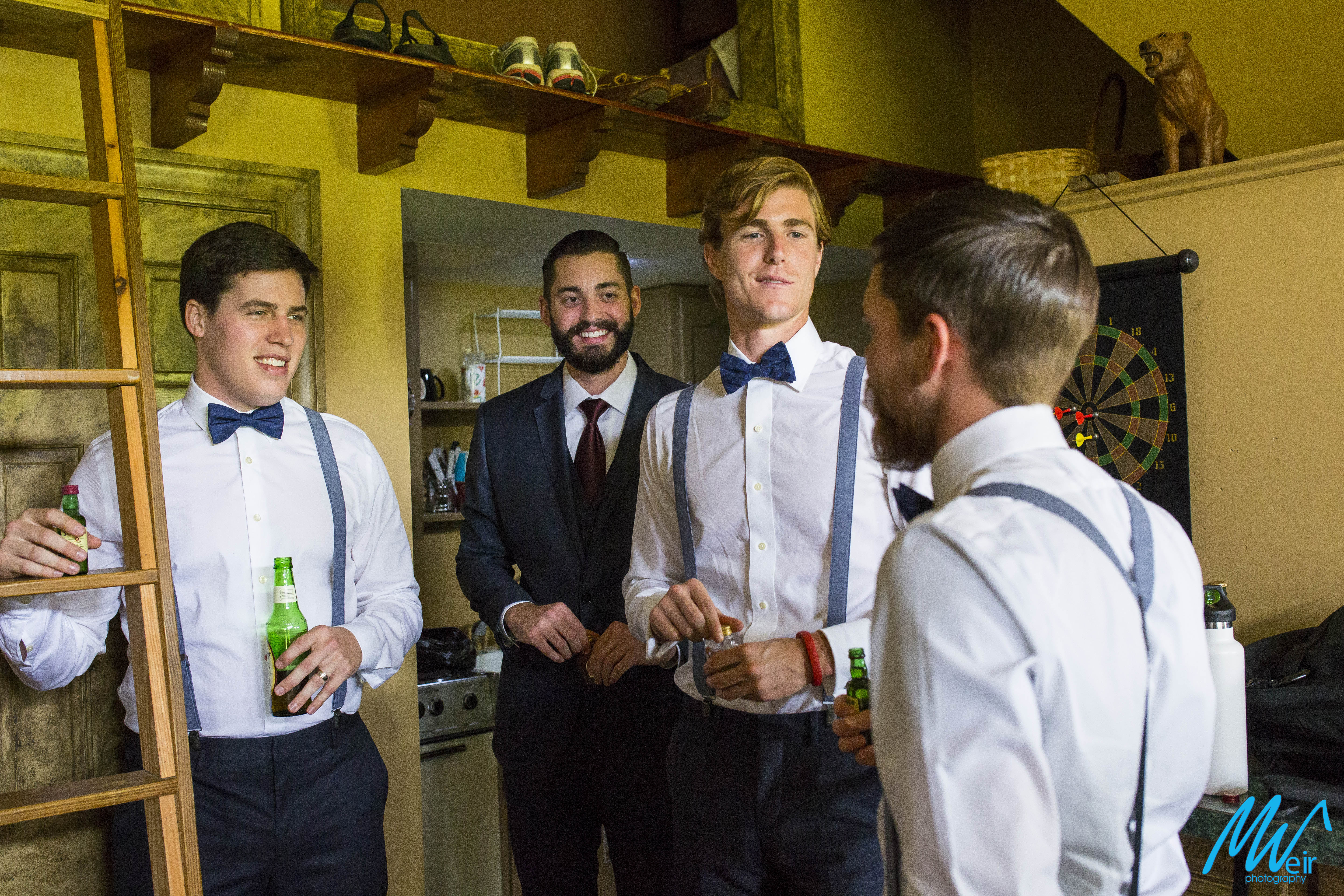 groomsmen party stand around laughing before wedding ceremony