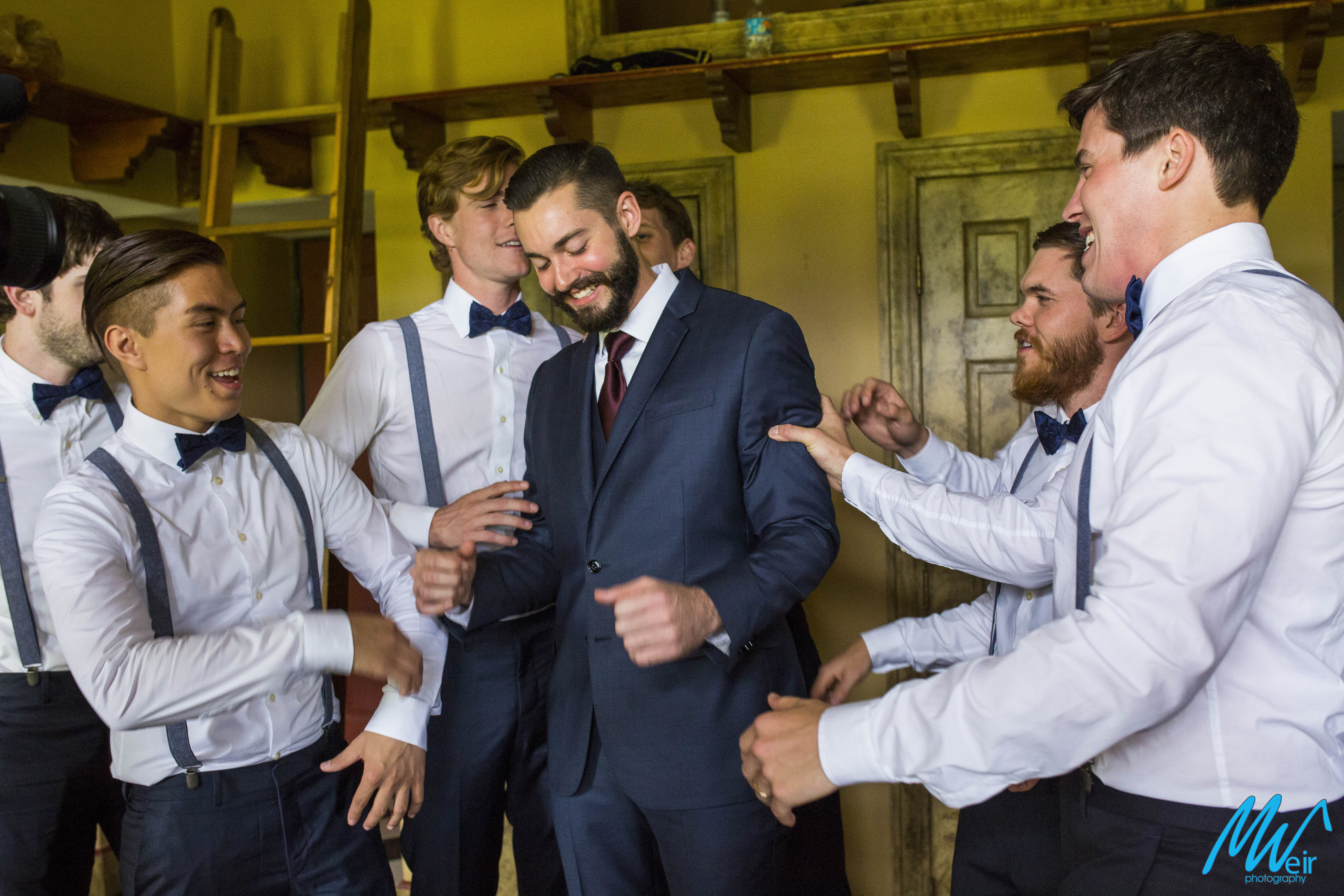 groomsmen joke around with groom before wedding ceremony