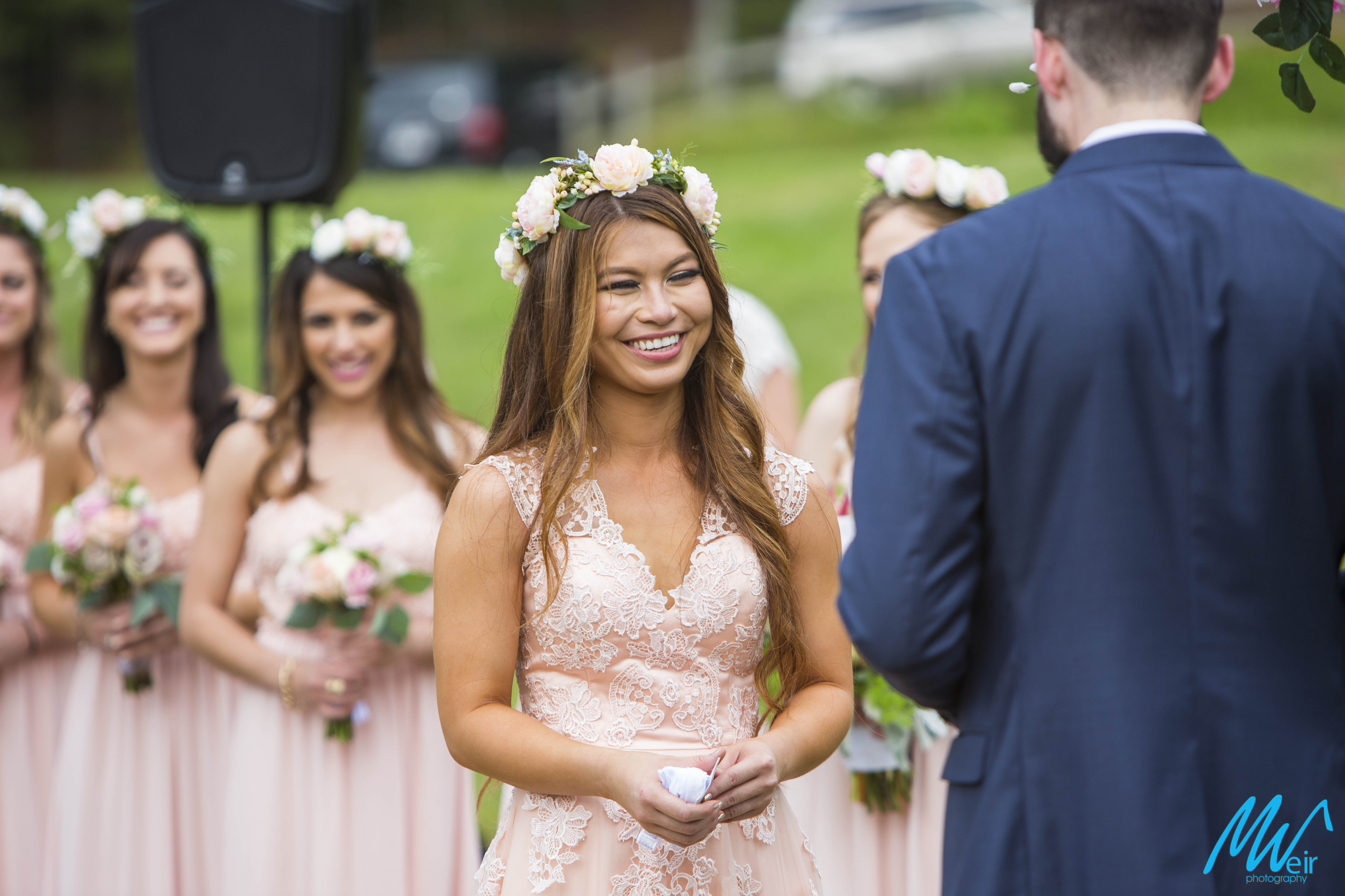 bride laughs during wedding ceremony in a field