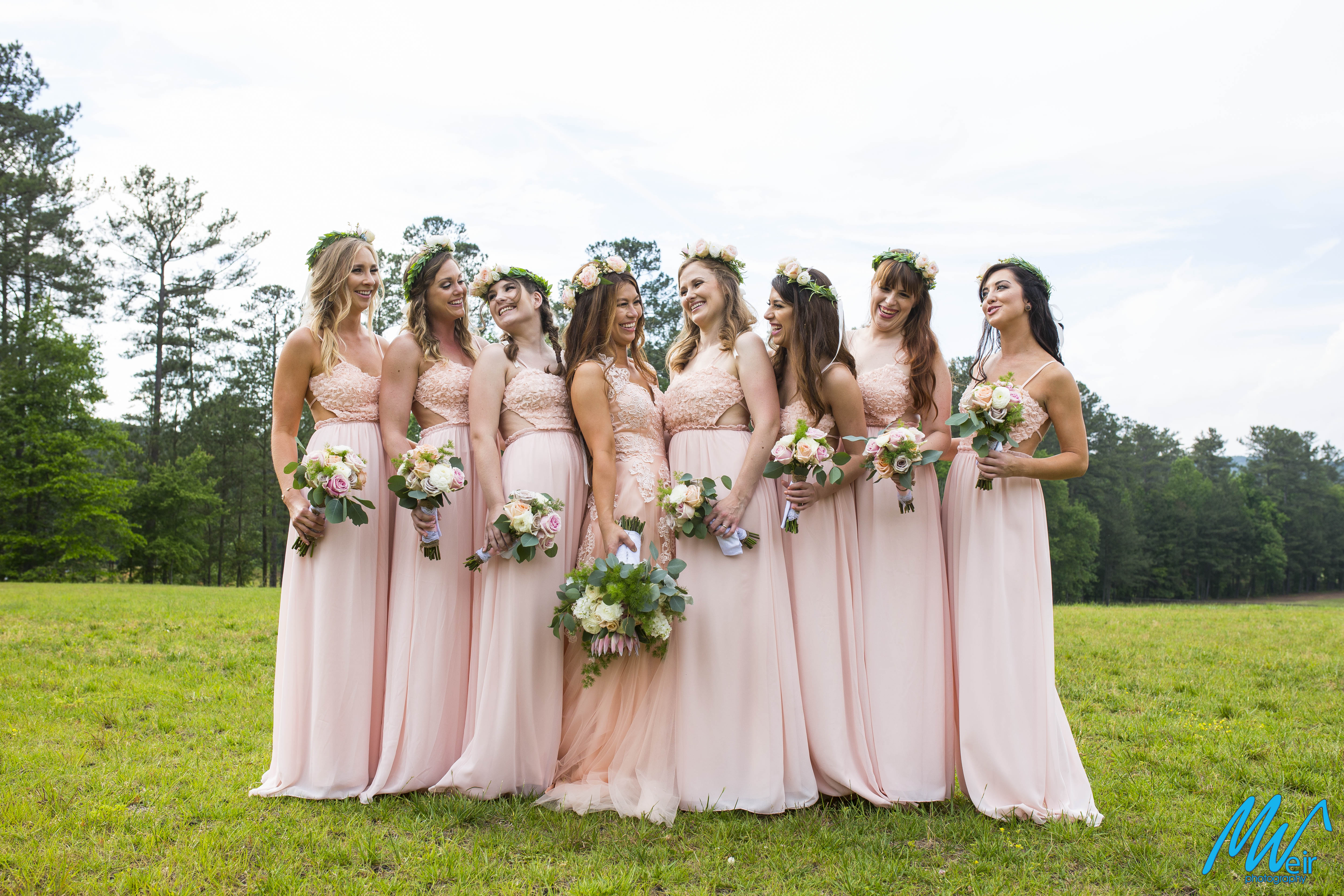bohemian hipster Bridesmaids in pale pink dresses standing in a field
