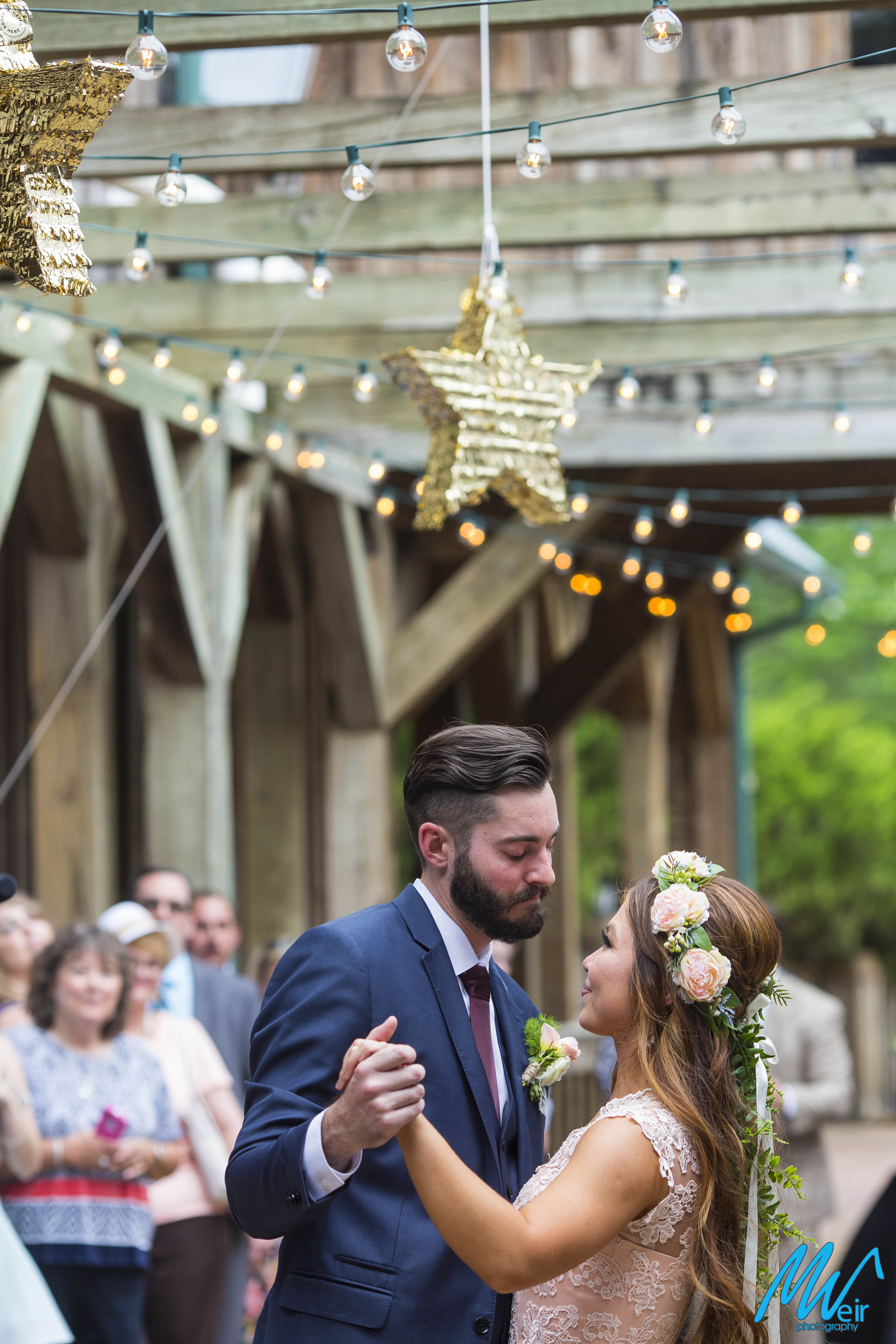 bride and groom share in a first dance under a star pinata