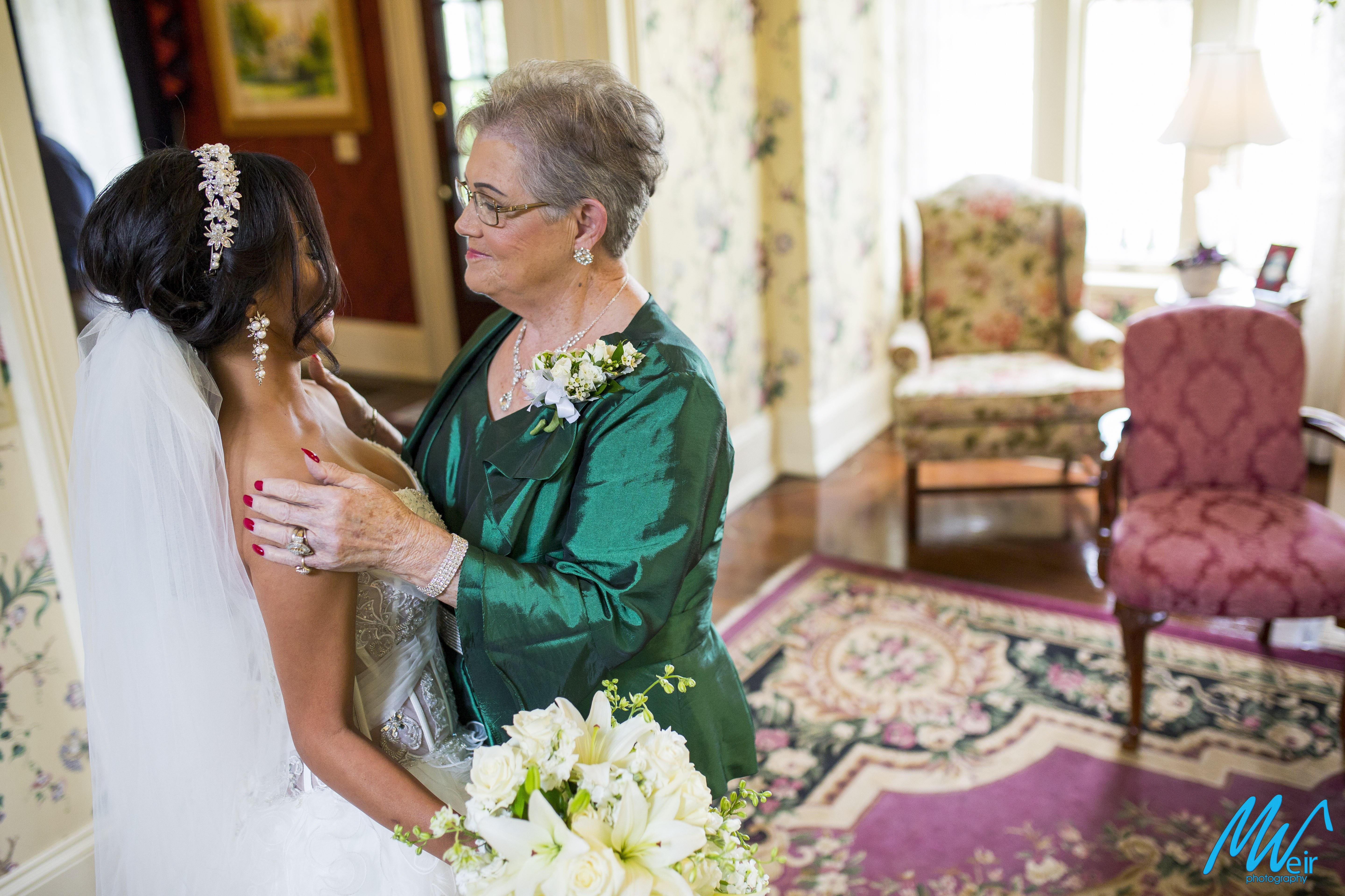 mother of the groom embraces bride in the foyer of wedding hall