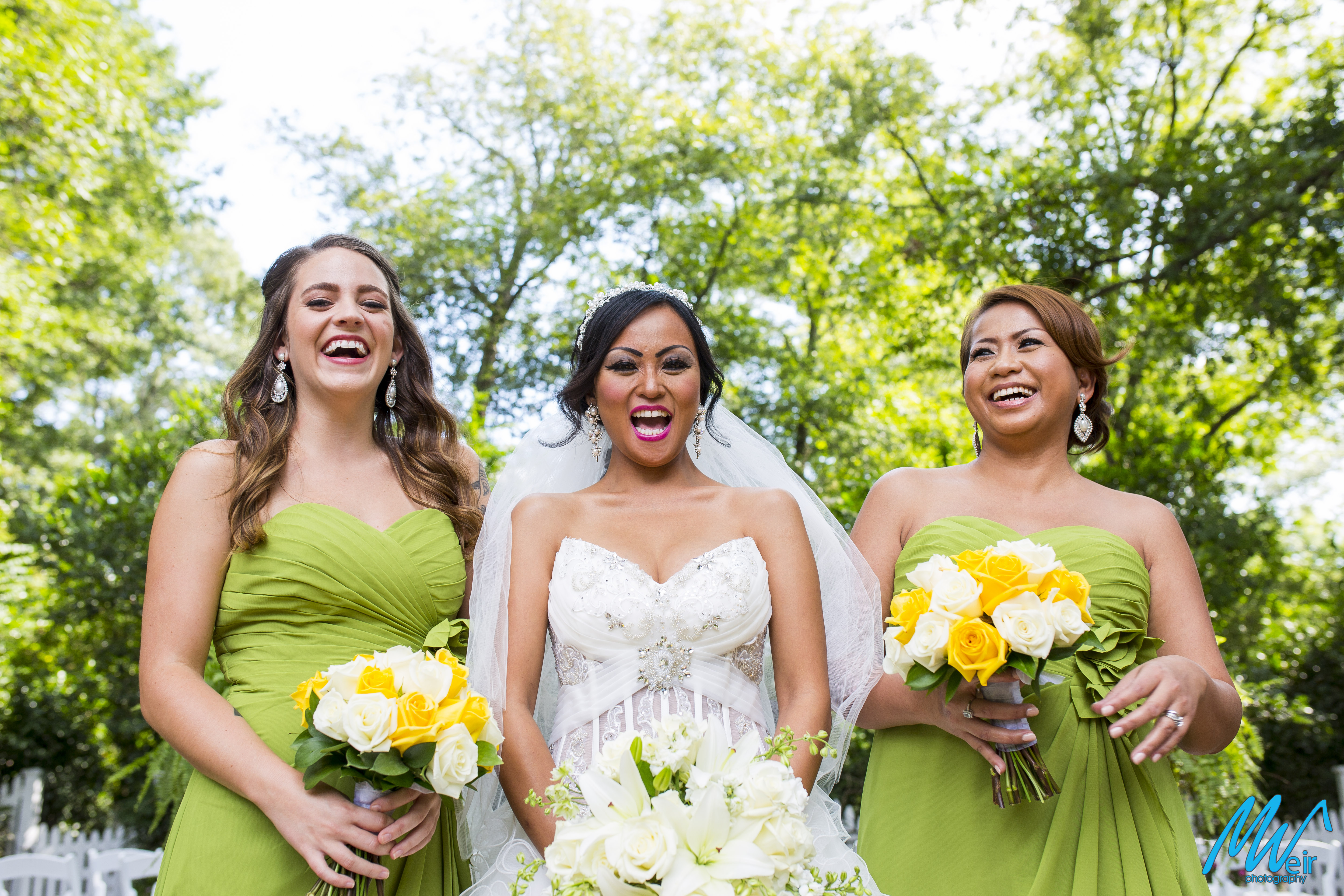bride and her bridesmaids laughing together in a garden