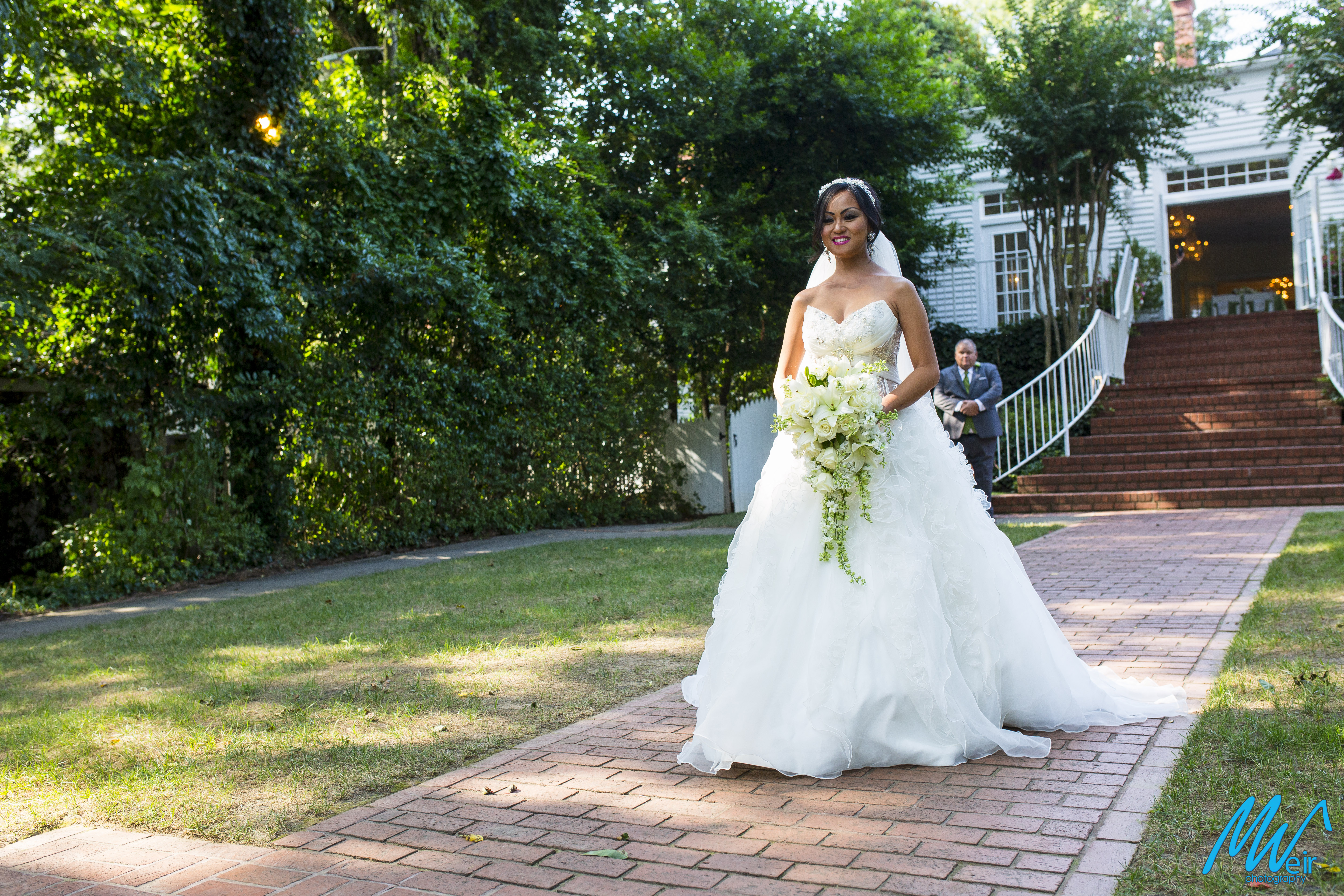 bride walks down brick aisle towards groom