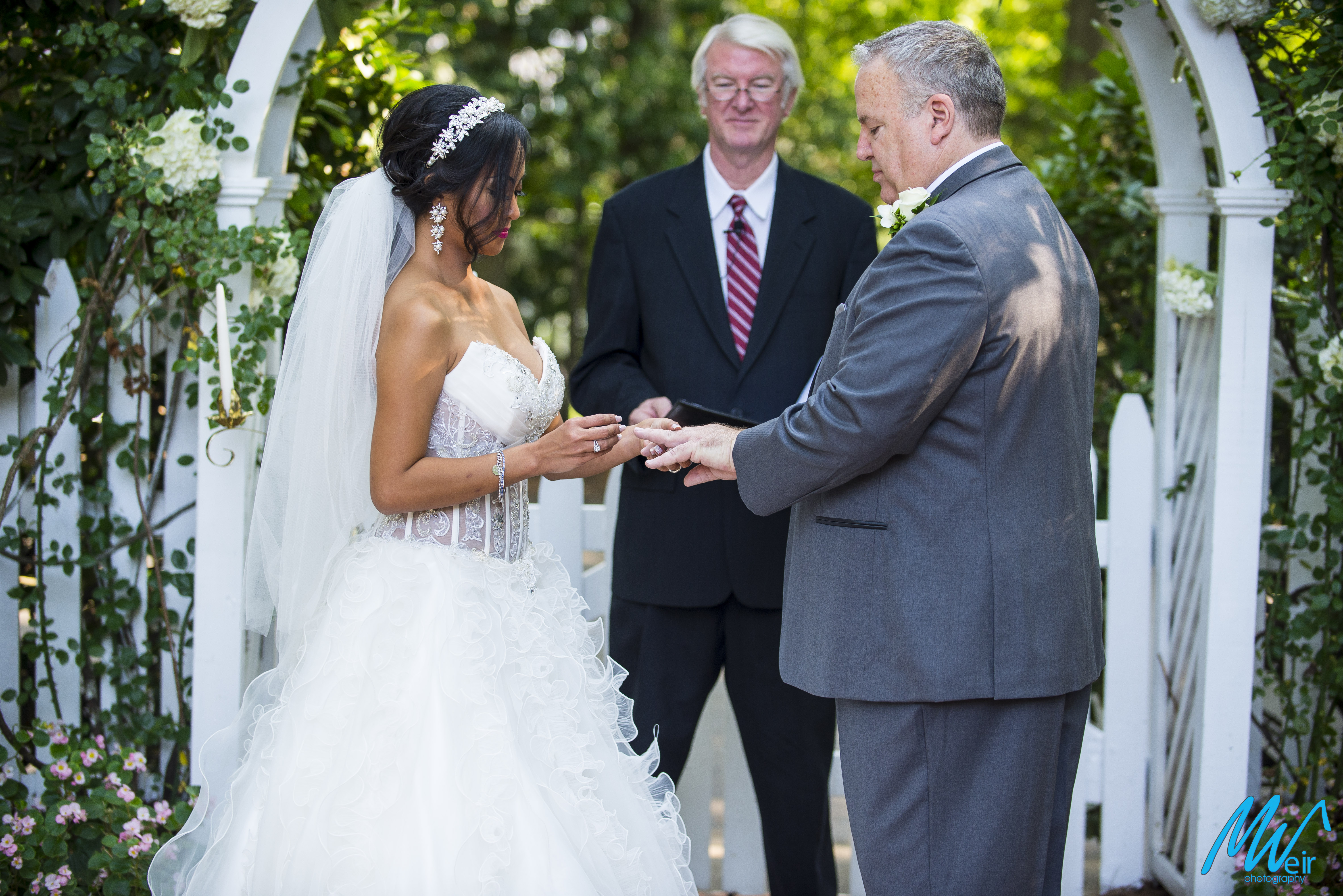bride puts wedding band on grooms finger