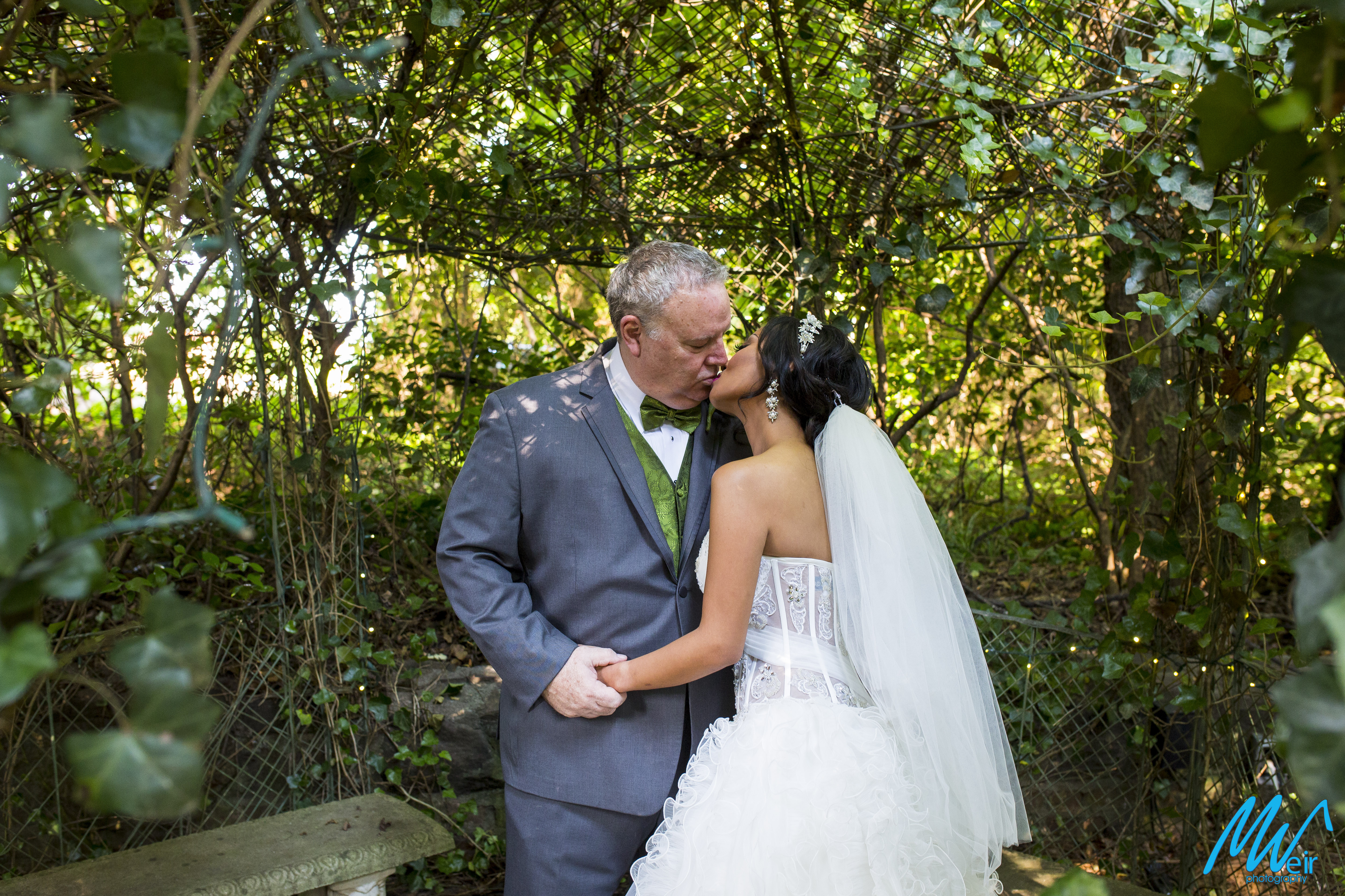 bride and groom kiss in the garden