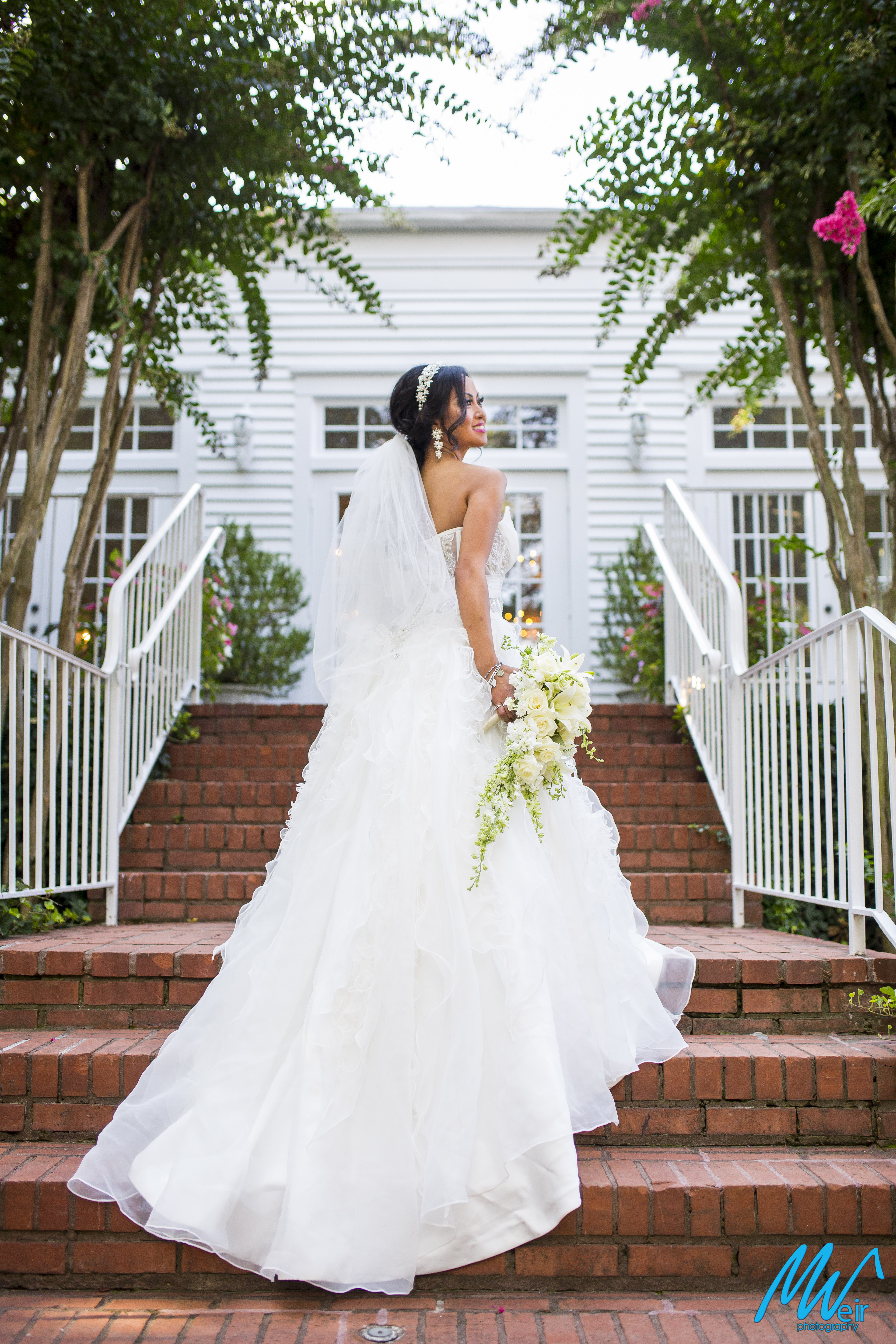 bride standing on brick grand staircase at whitlock inn