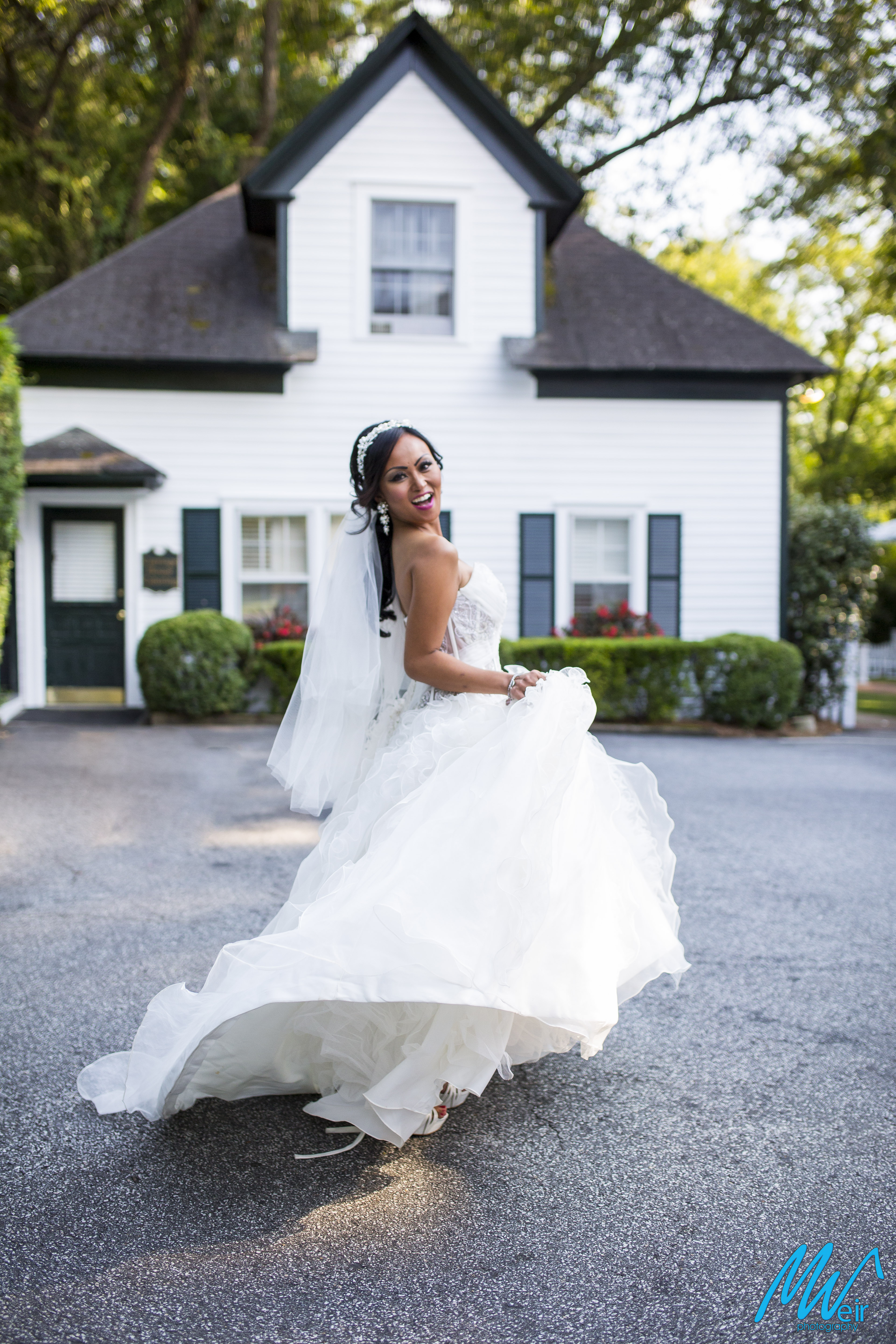 bride twirling her dress in front of cute cottage