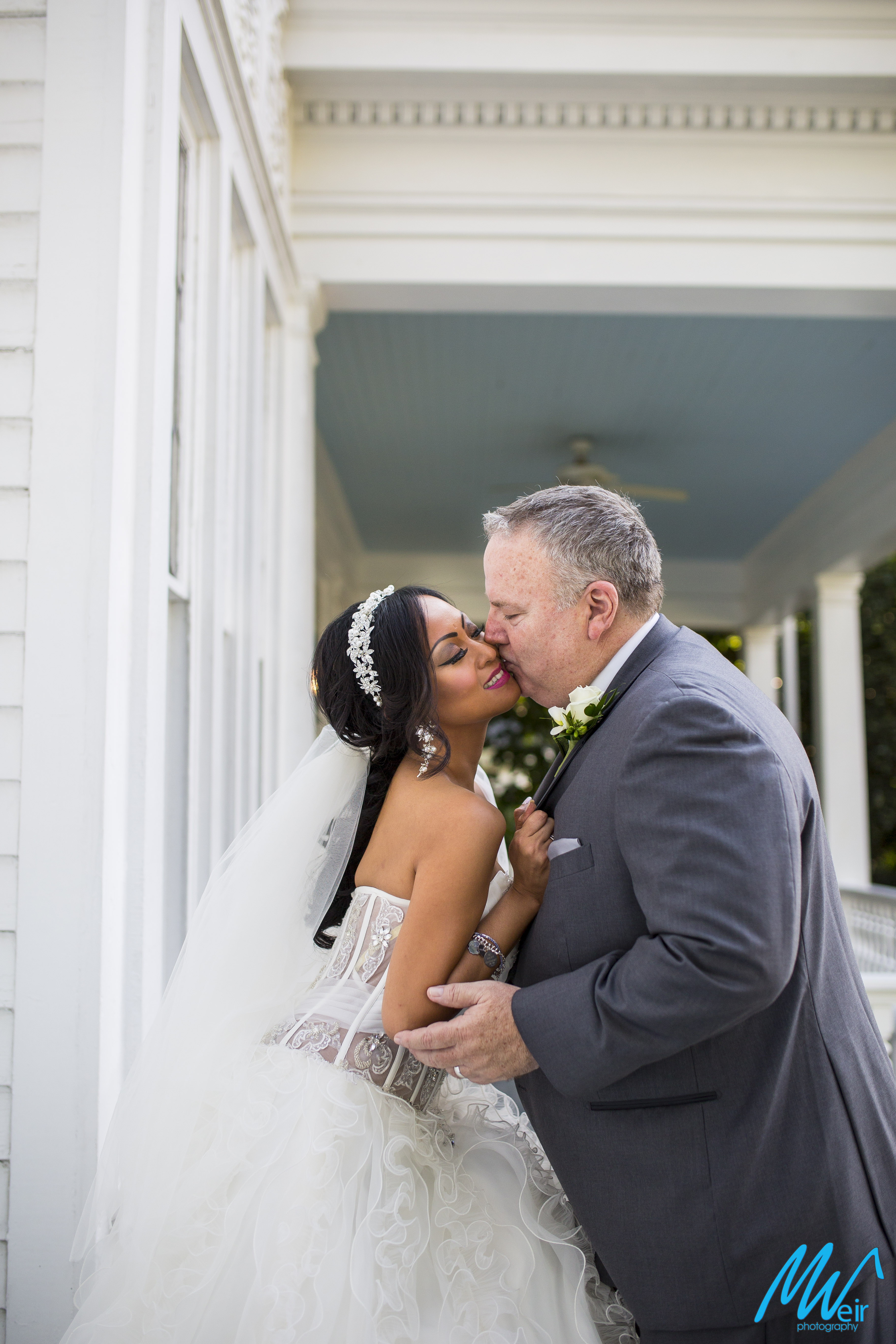 bride and groom share a smooch kiss on whitlock inn front porch