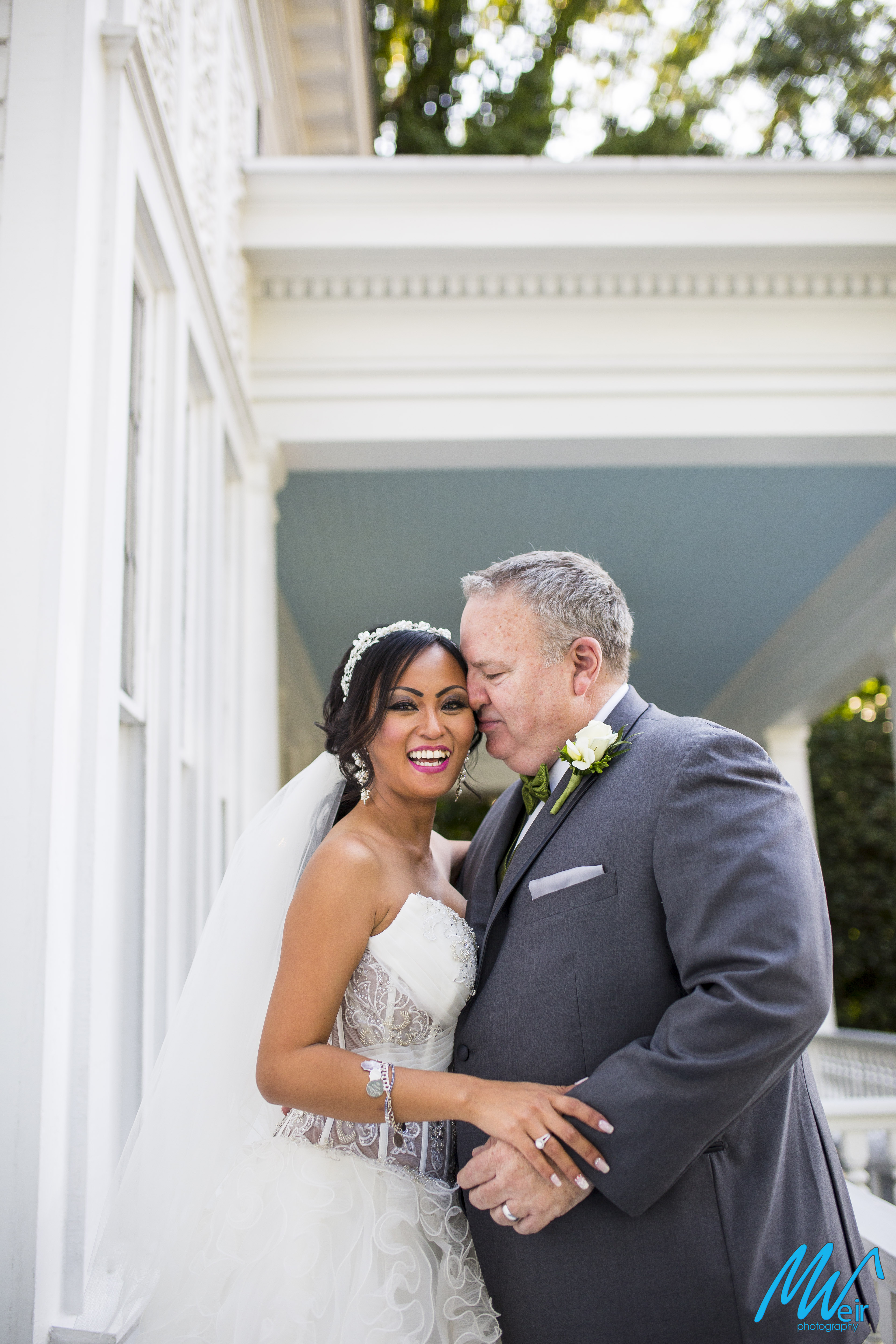 grooms kisses brides cheek on front porch of whitlock inn