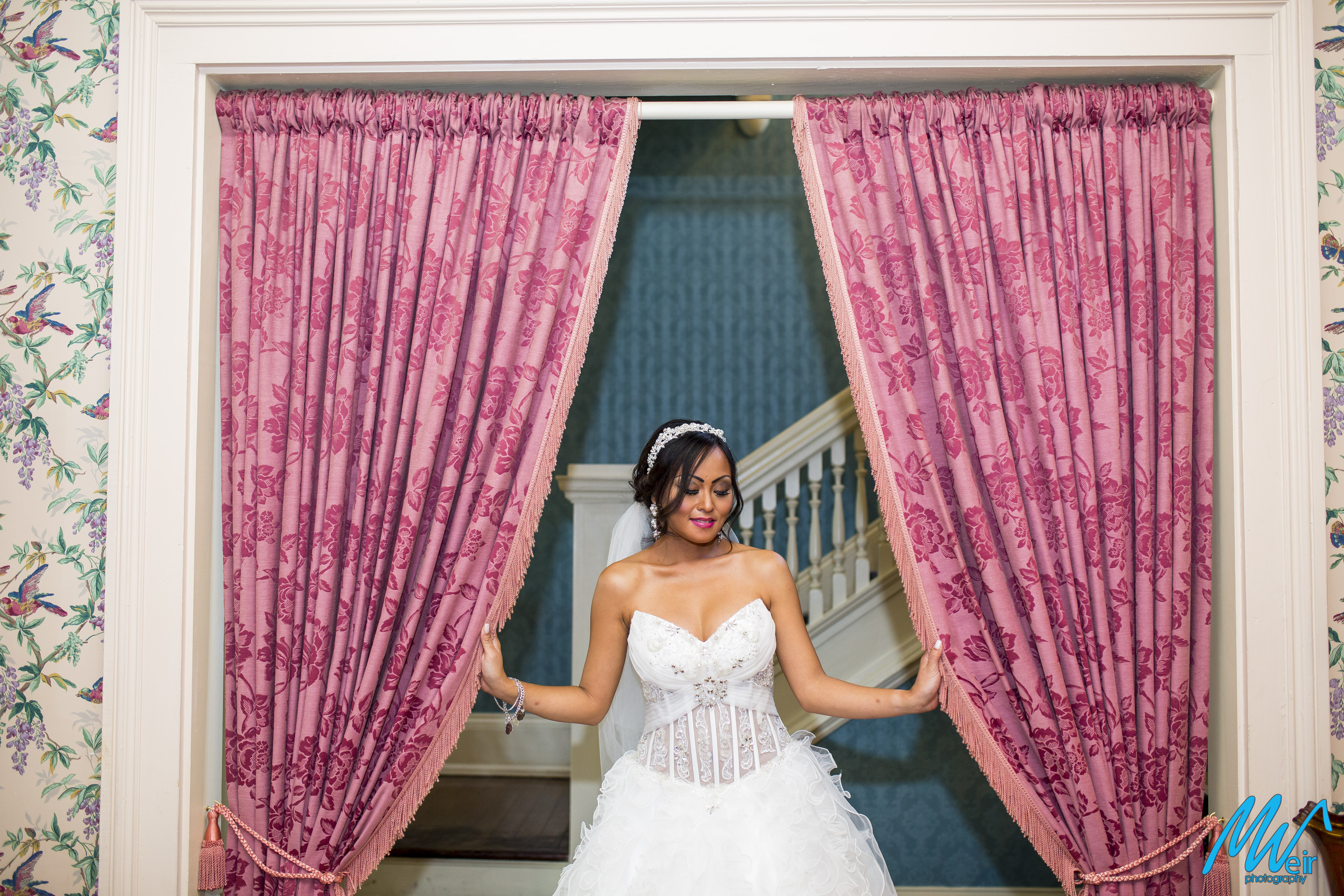 bride standing between red curtains