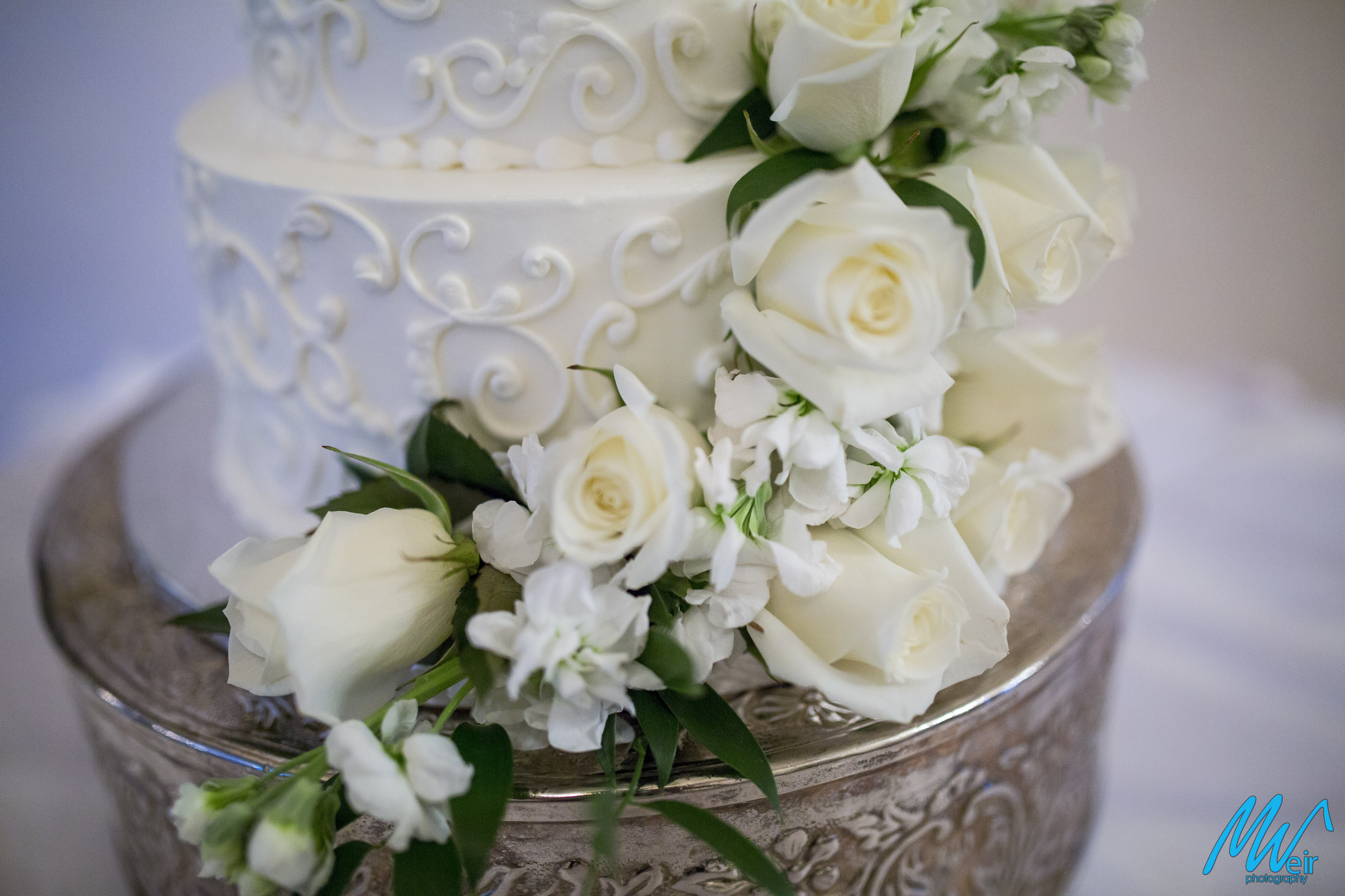 detail of white roses on 3 tiered wedding cake