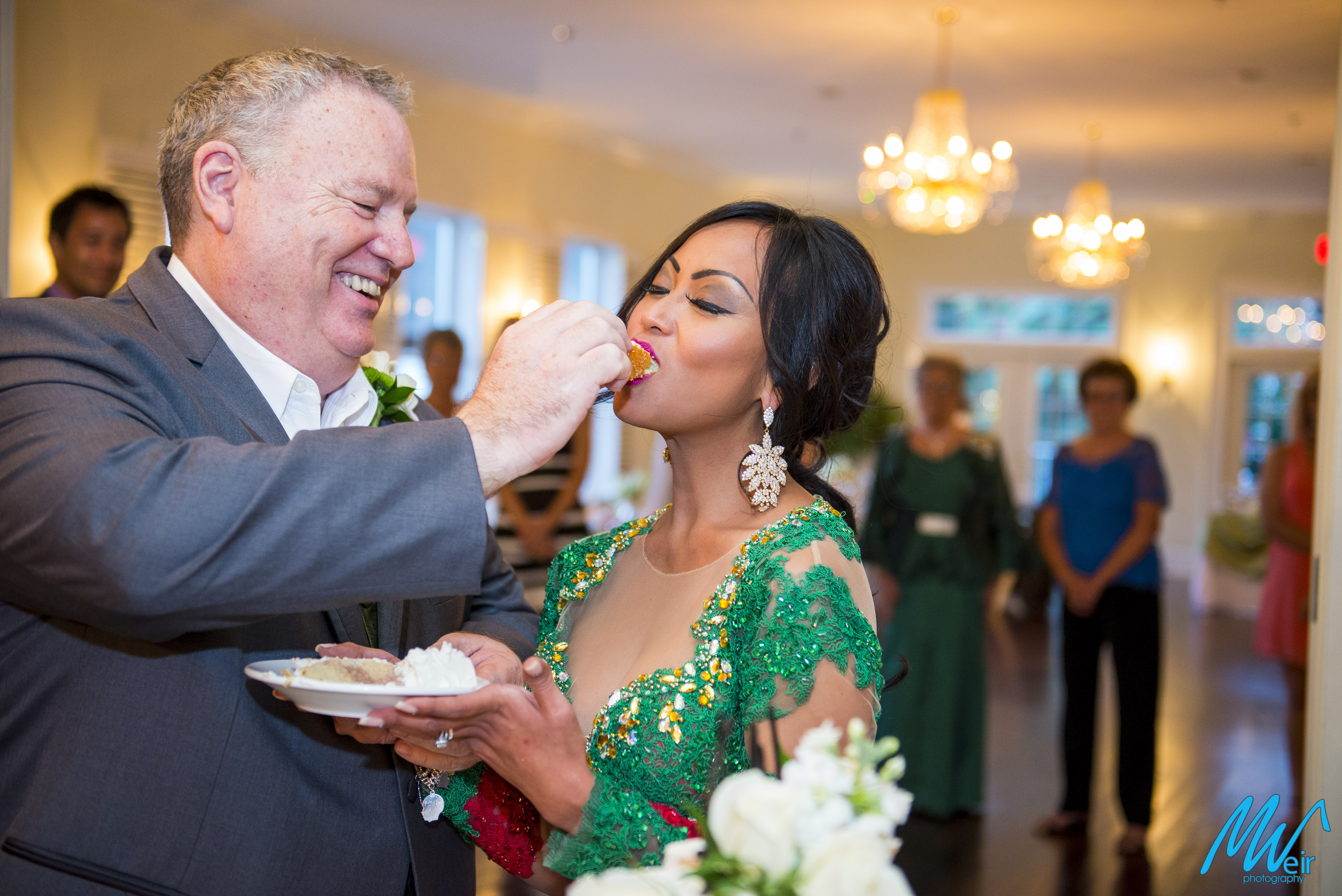groom feeds wedding cake to his bride