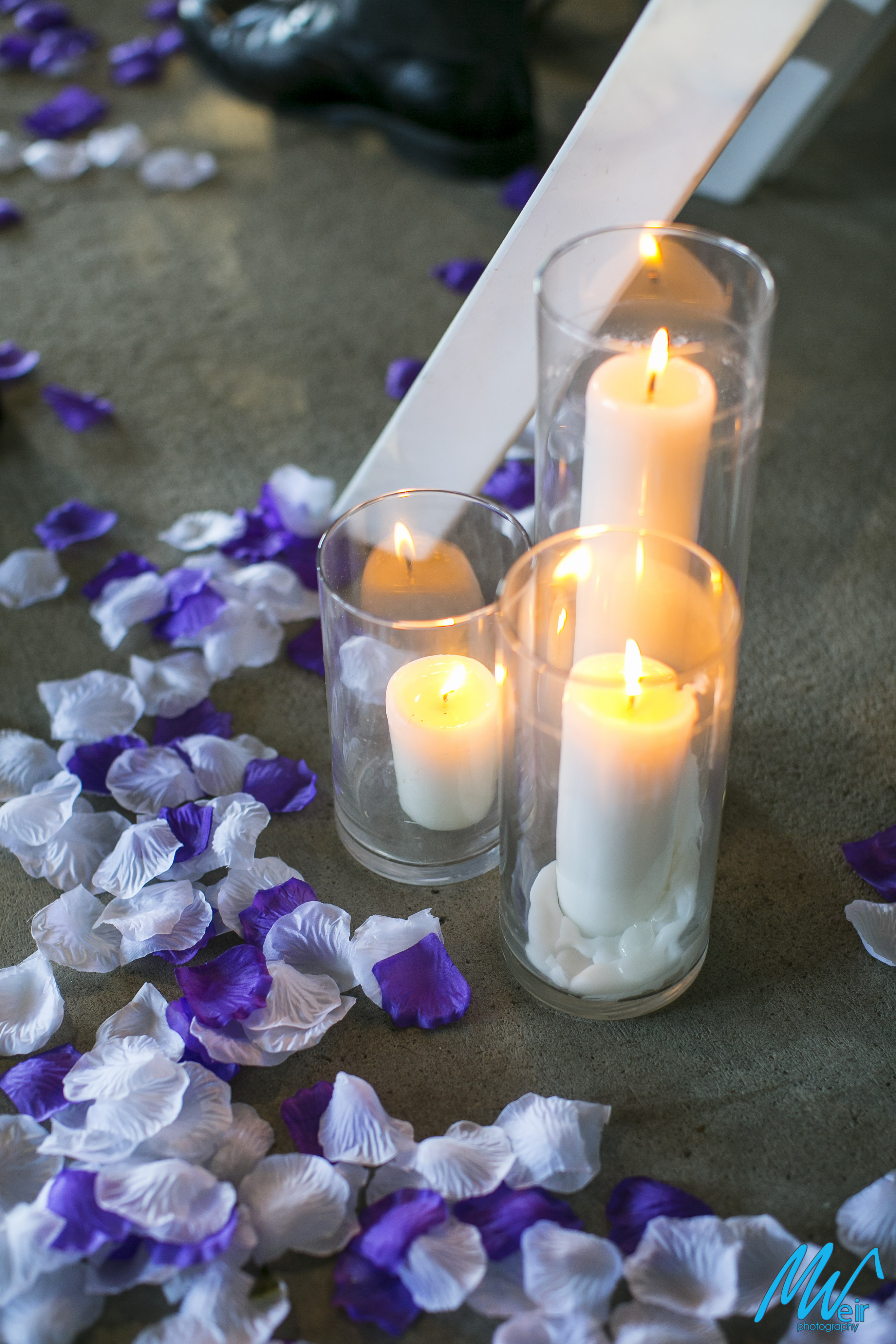 candles and flower petals line wedding aisle