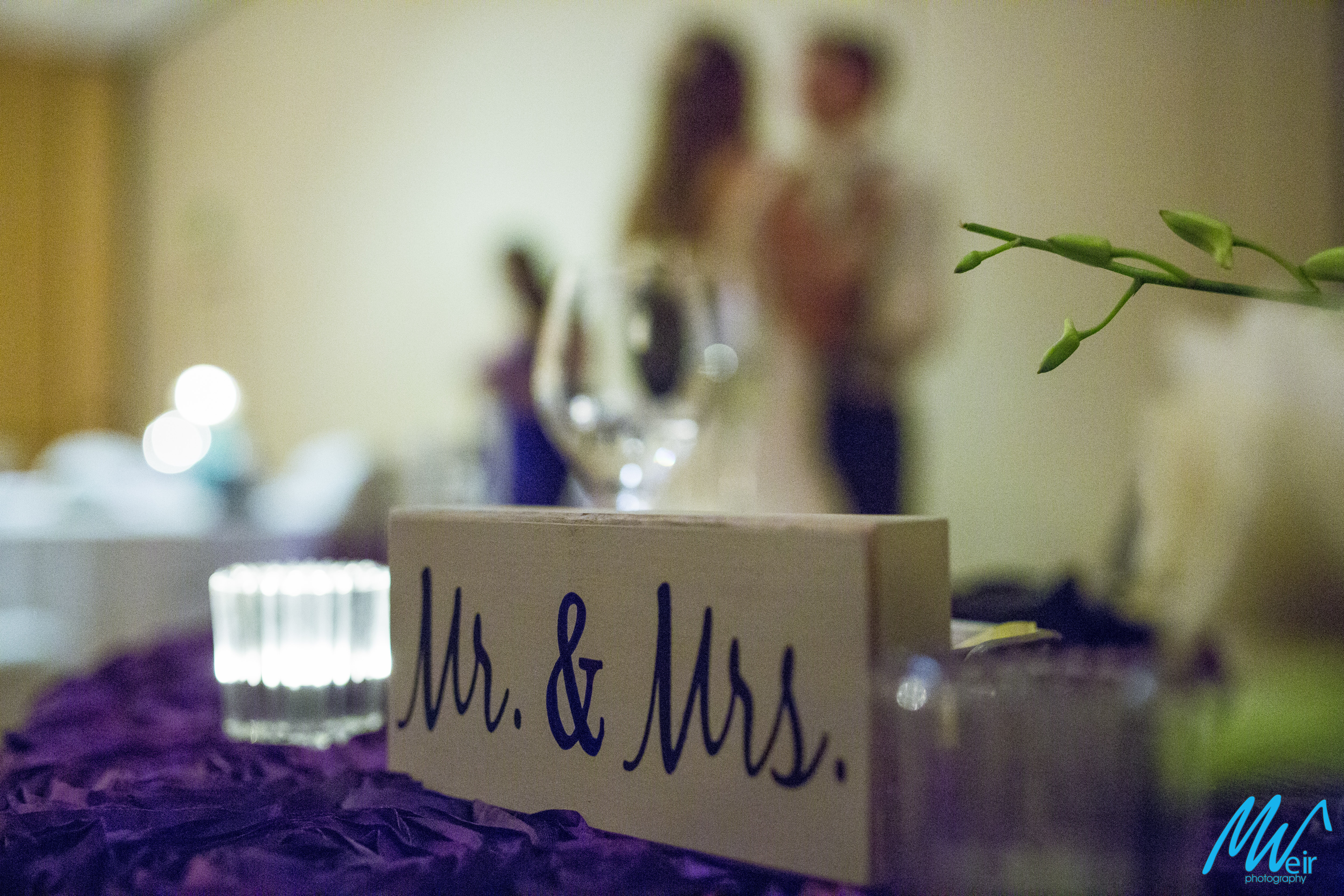 detail of mr and mrs sign with bride and groom in background