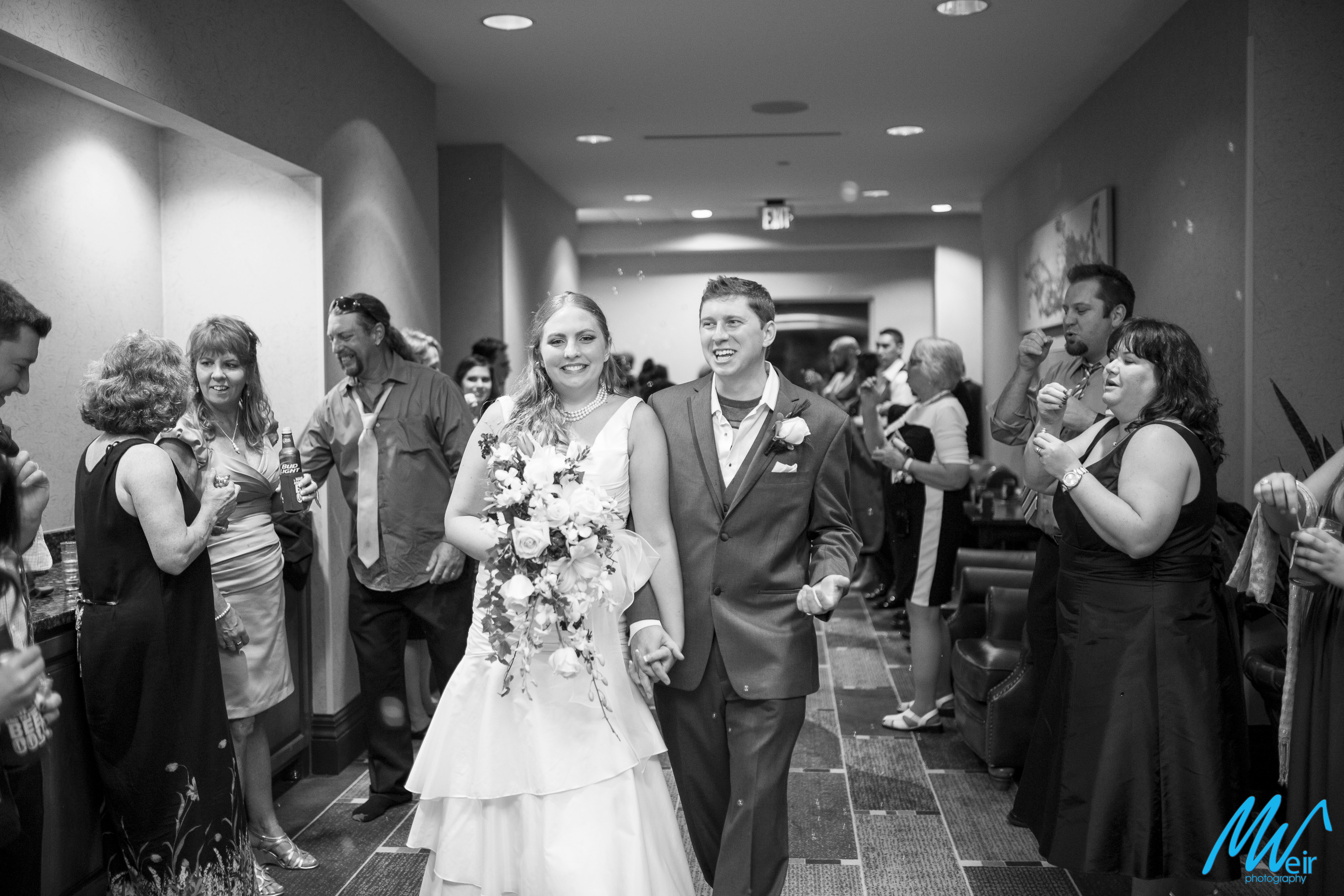 bride and groom exit inside the hotel with tons of bubble