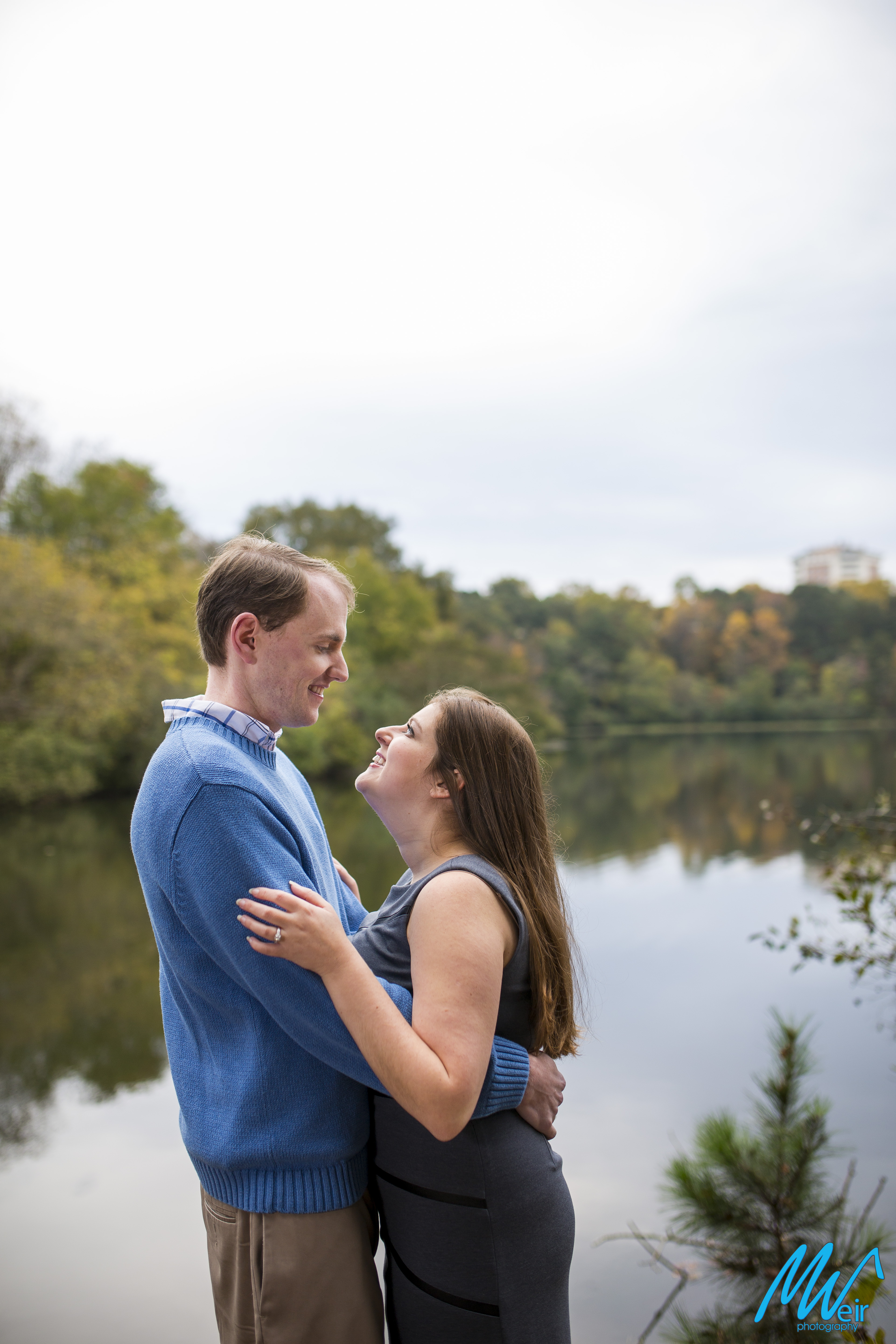 couple look at each other in front of a lake