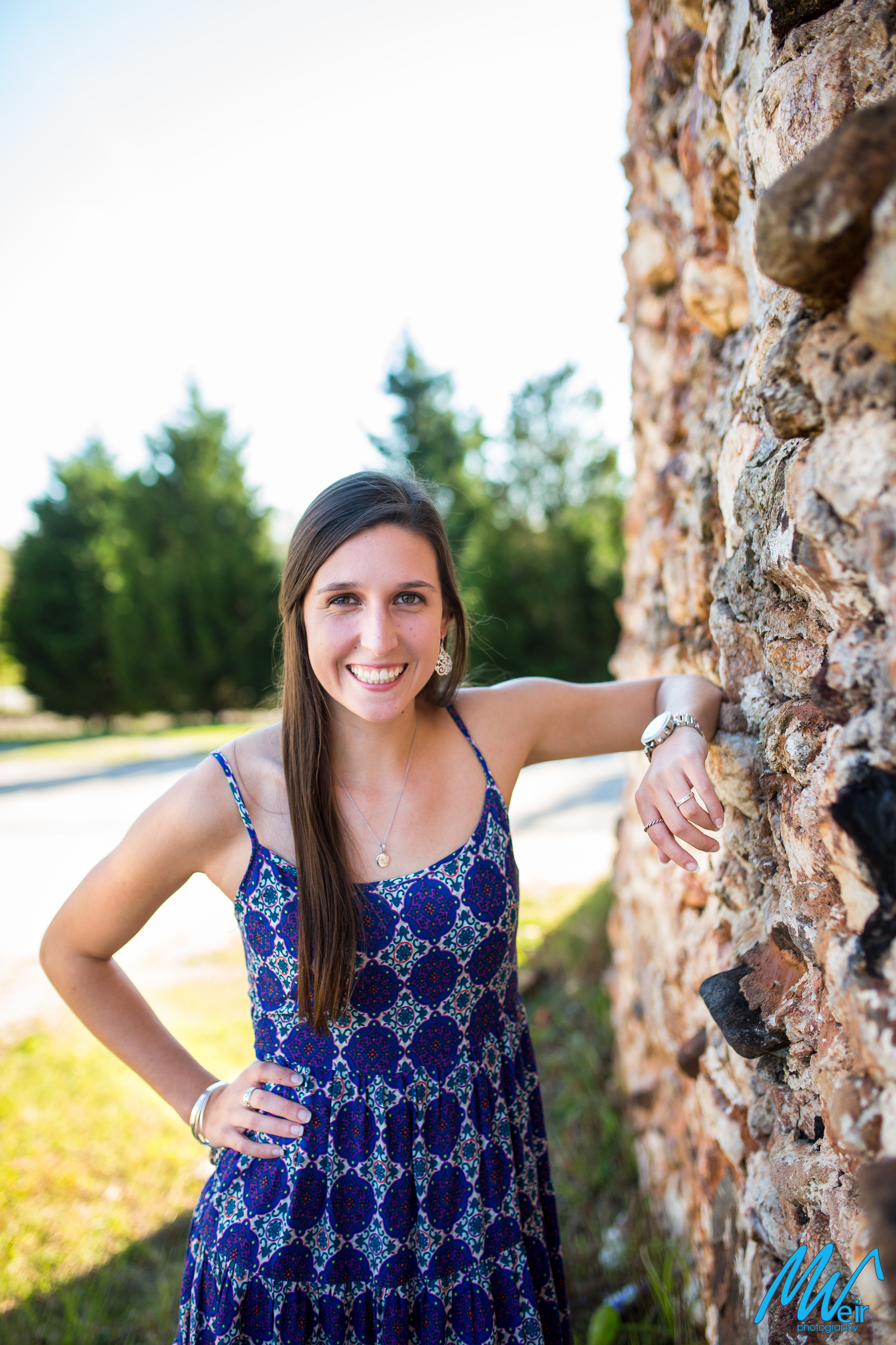 high school senior in front of a stone wall