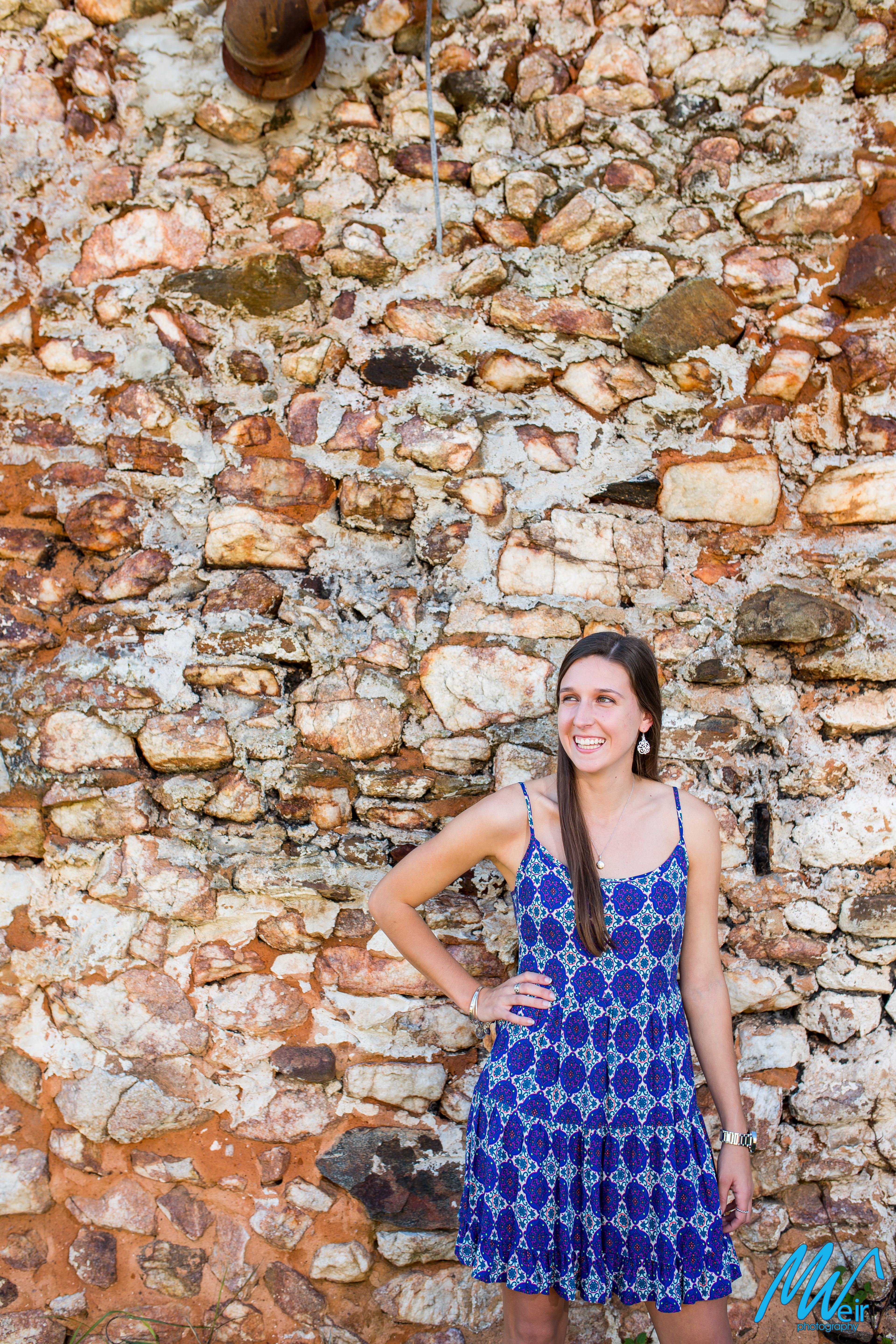 high school senior in front of a stone wall