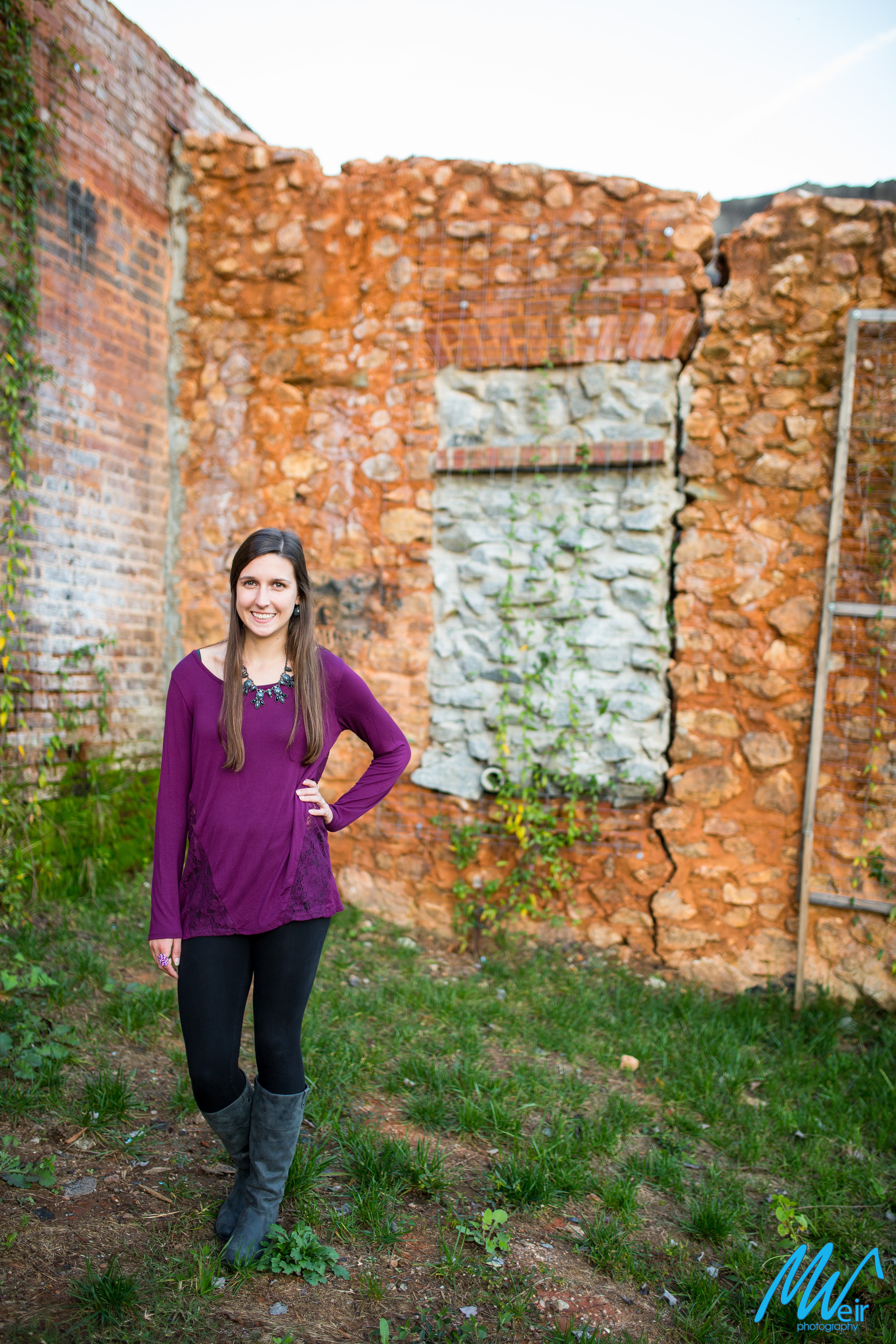 high school senior girl in front of stone wall