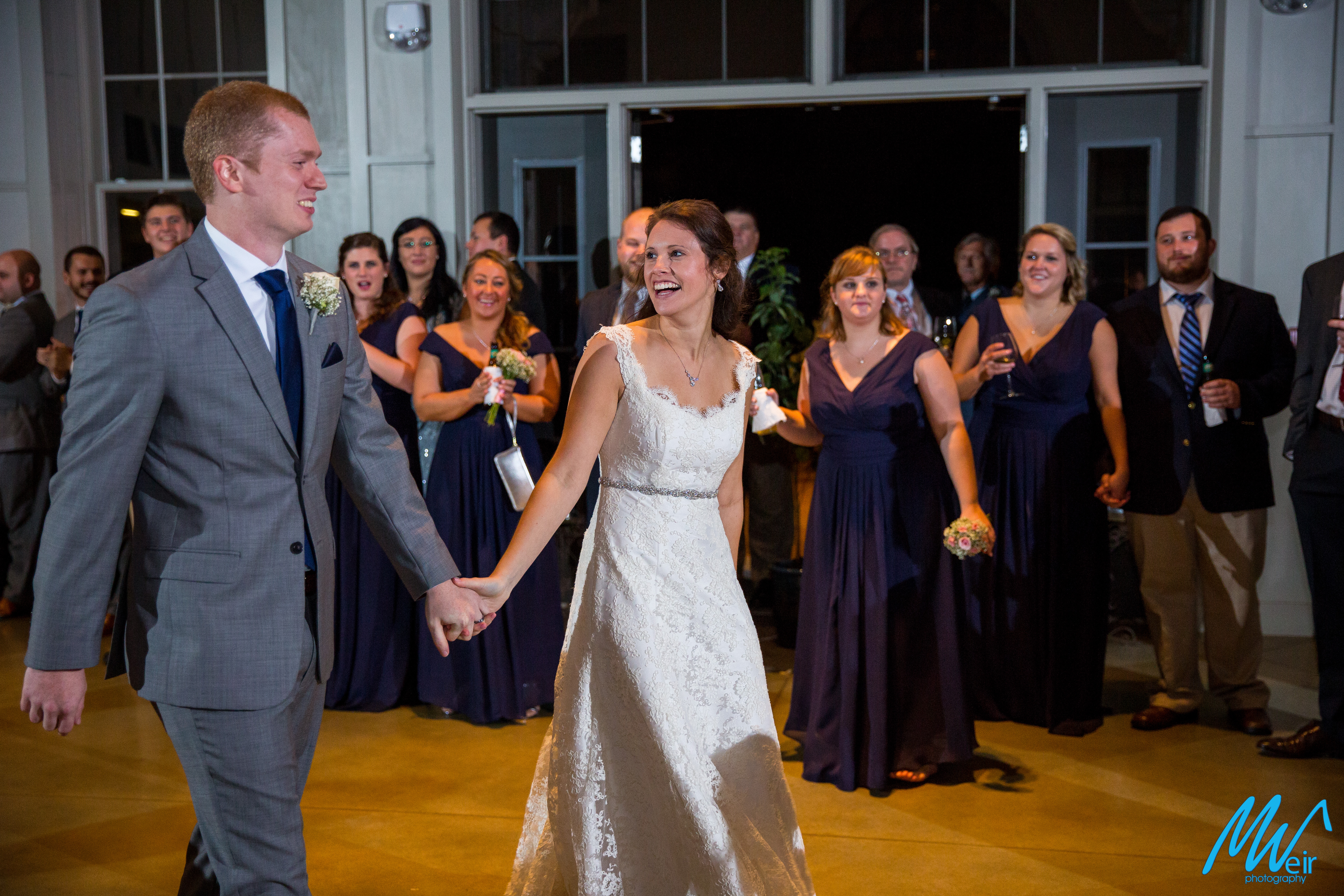 bride and groom walk in to reception for their first dance