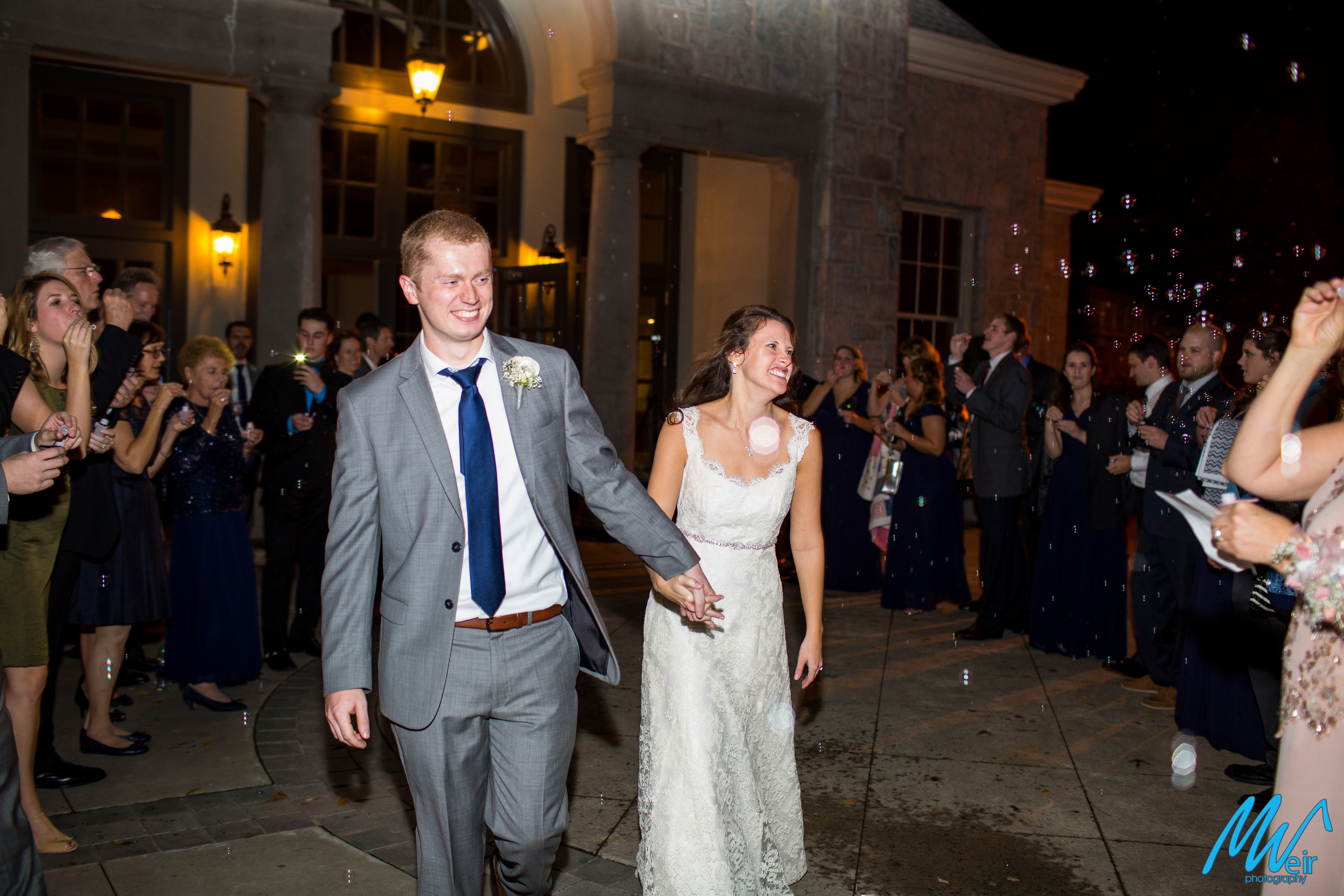 bride and groom exit their wedding with bubbles