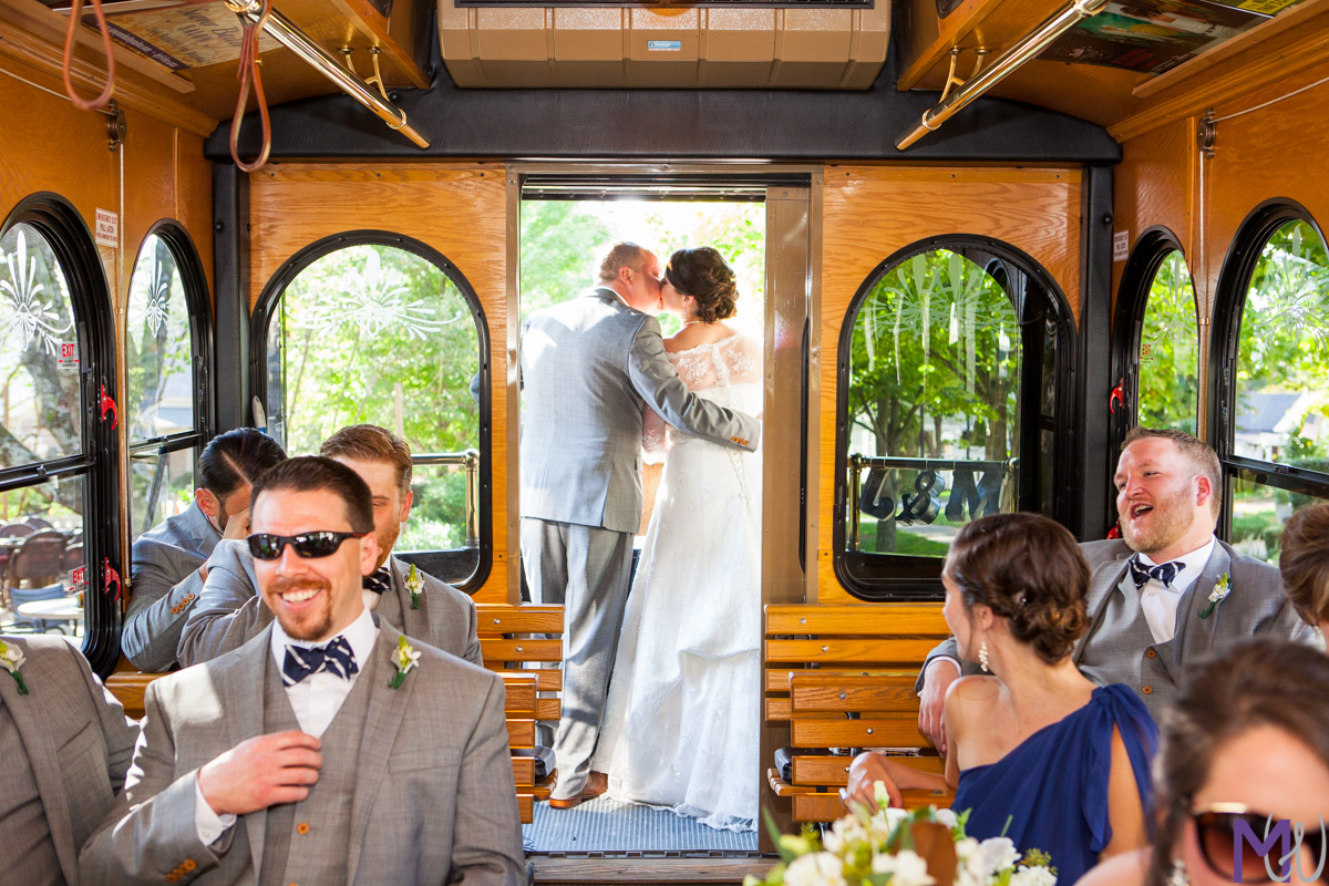 bride and groom kiss at the back of a trolley